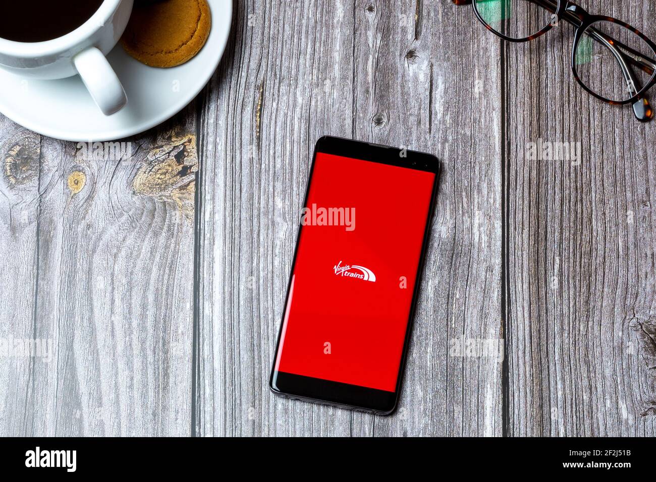 Un telefono cellulare o un telefono cellulare posato su un legno Tavolo con l'app Virgin Trains aperta sullo schermo Foto Stock