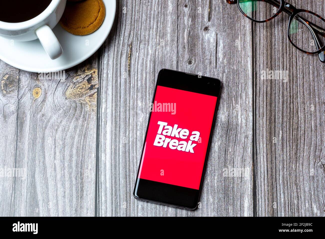 Un telefono cellulare o un telefono cellulare posato su un legno Tavolo con l'app Take a Break aperta sullo schermo Foto Stock