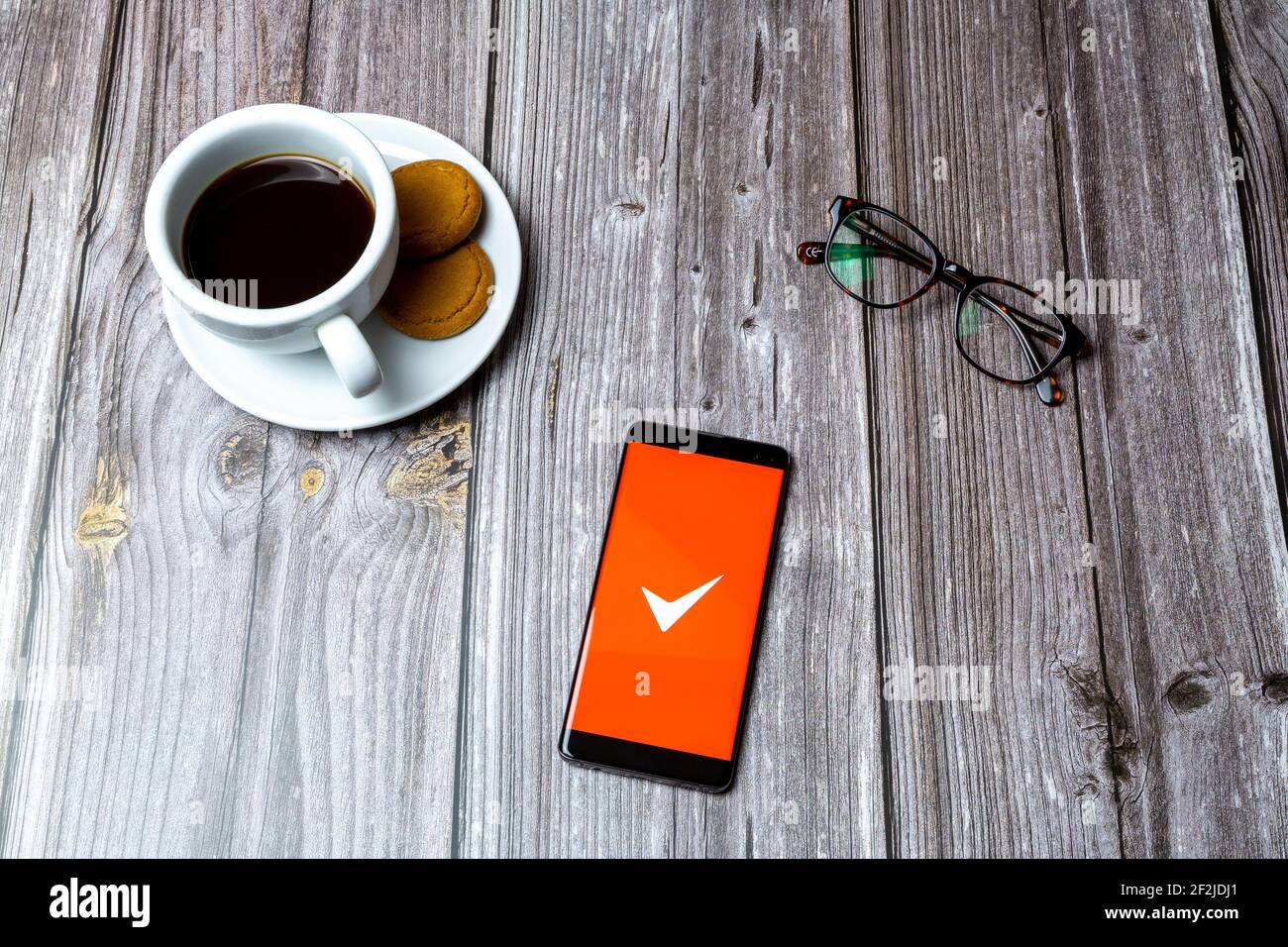 Un telefono cellulare o un telefono cellulare posato su un legno Tabella con l'app fattura semplice aperta sullo schermo Foto Stock