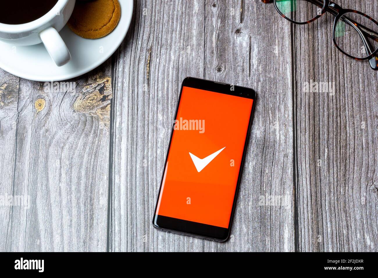 Un telefono cellulare o un telefono cellulare posato su un legno Tabella con l'app fattura semplice aperta sullo schermo Foto Stock