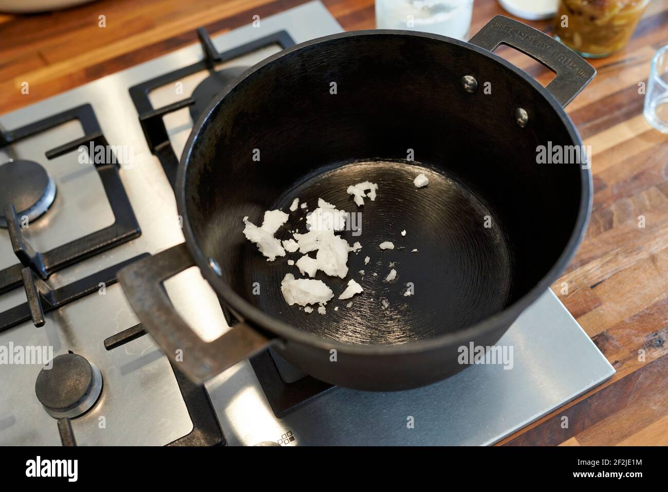 L'olio di cocco viene riscaldato in una pentola nera su un stufa a gas Foto  stock - Alamy