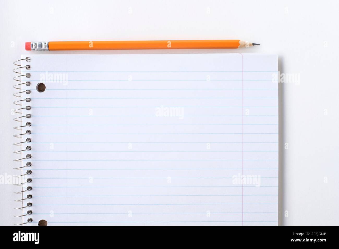 Notebook vuoto a righe e matita. Blocco note a spirale e matita arancione. Foto Stock