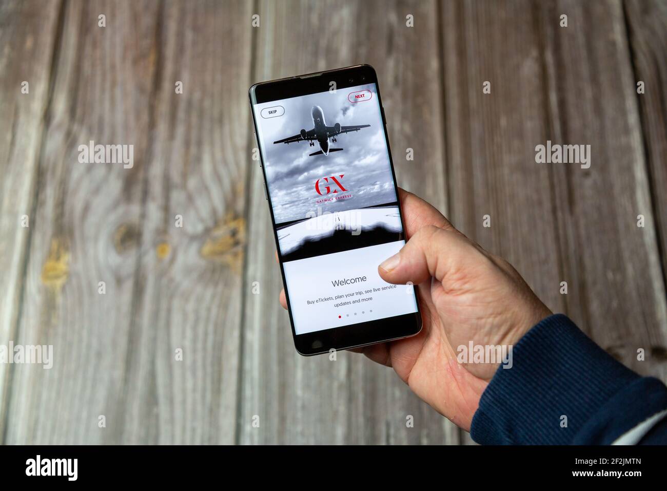 Un telefono cellulare o un telefono cellulare in attesa in un Mano con l'app Gatwick Express aperta sullo schermo Foto Stock