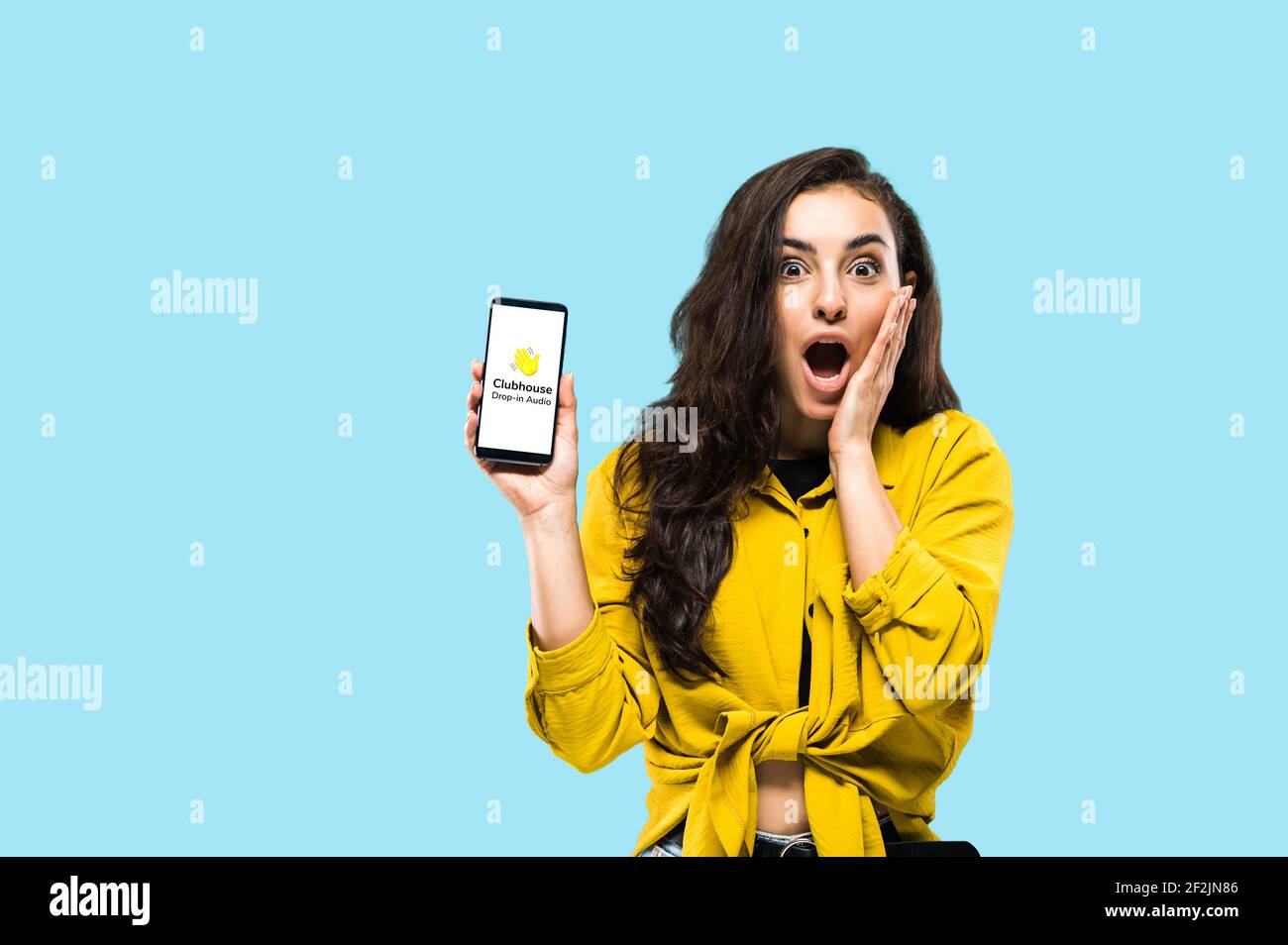 Kiev, Ucraina - 28 febbraio 2021. Una ragazza entusiasta tiene iPhone con il logo dell'app Clubhouse sullo schermo, app solo per la comunicazione audio, di persone diverse in tutto il mondo Foto Stock