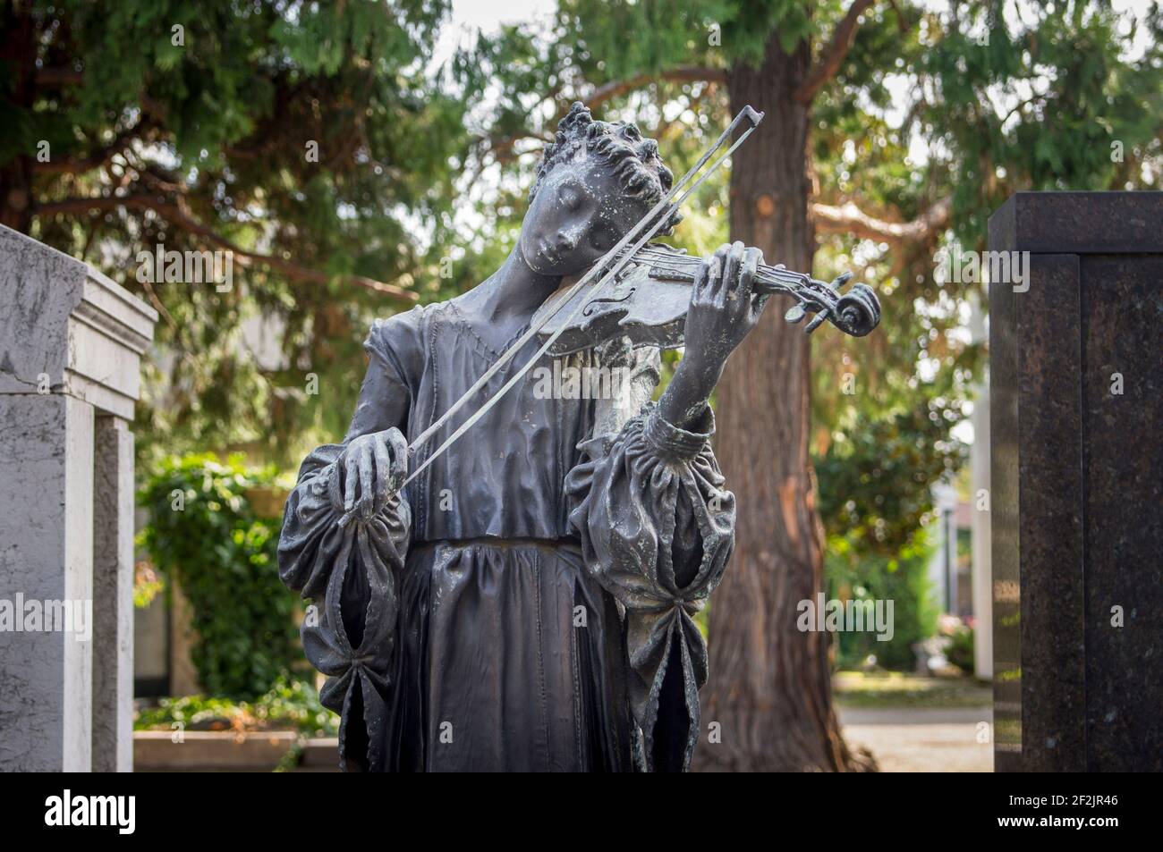 Donna che suona violino su una tomba, figura di bronzo, Cimitero Centrale 'Cimitero Monumentale', Milano, Italia Foto Stock