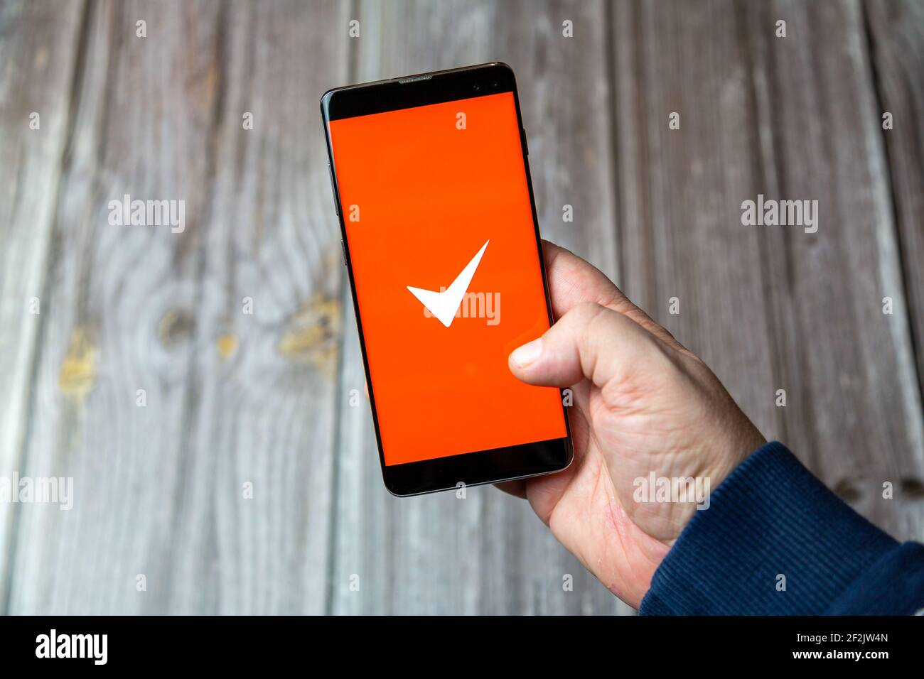 Un telefono cellulare o un telefono cellulare in attesa in un Mano con l'app fattura semplice aperta sullo schermo Foto Stock