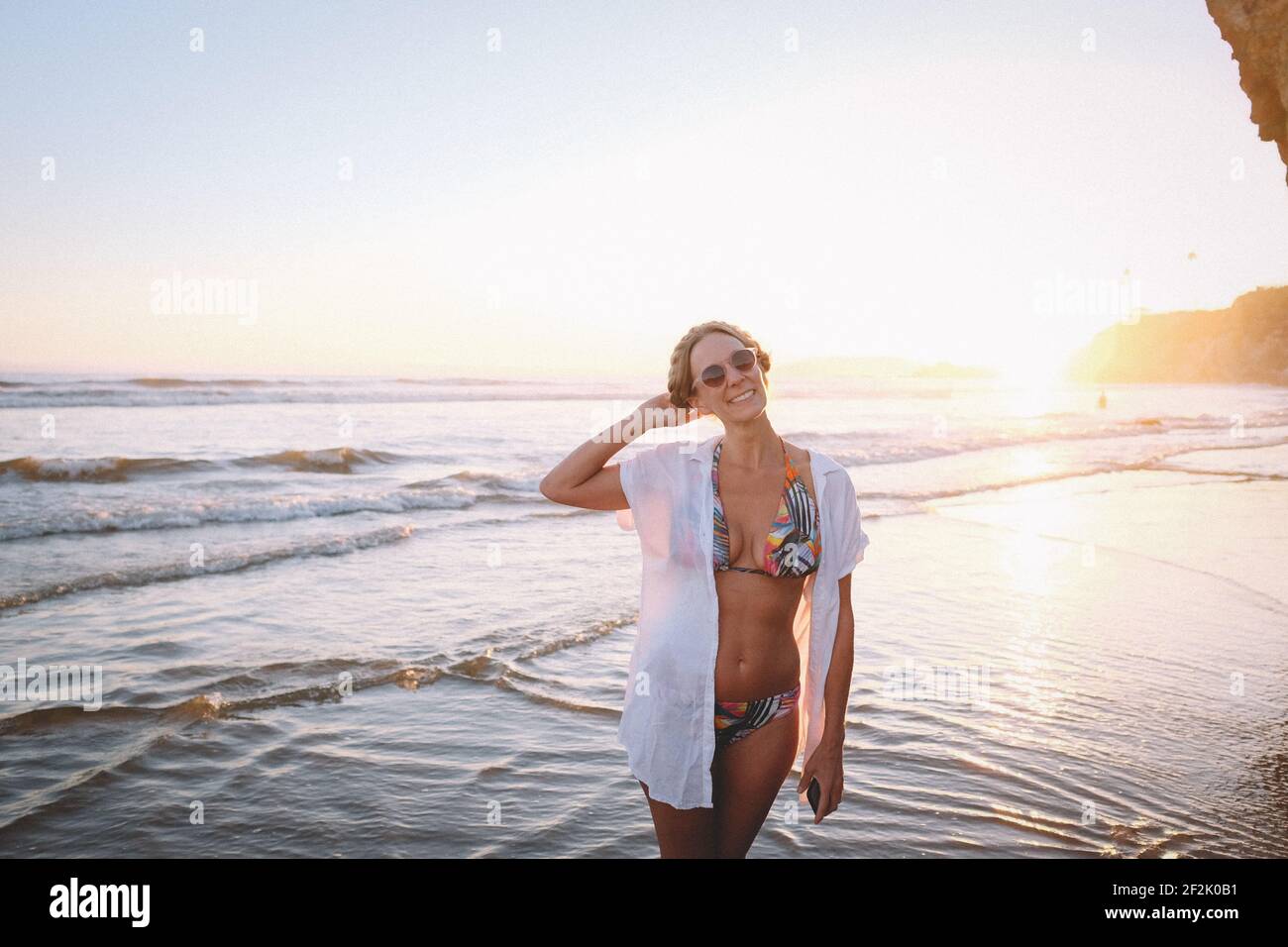 Donna in Bikini tropicale sulla spiaggia al tramonto Foto Stock