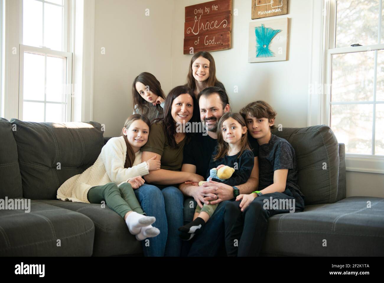 Bella famiglia di sette persone sedute sul divano nel loro soggiorno Foto  stock - Alamy