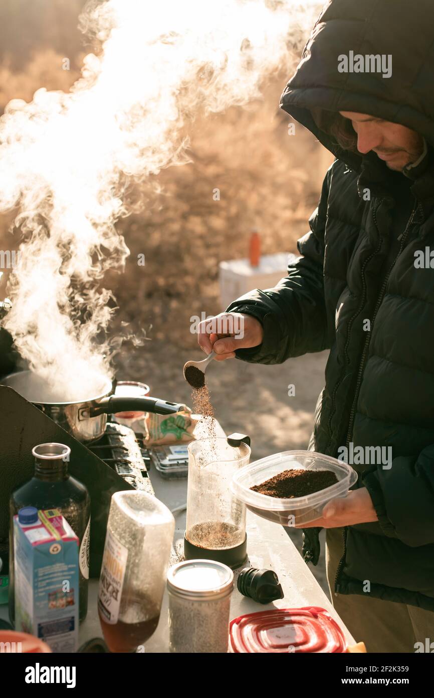 Uomo che prepara il caffè mentre esplora il Canyonlands National Park durante la vacanza Foto Stock