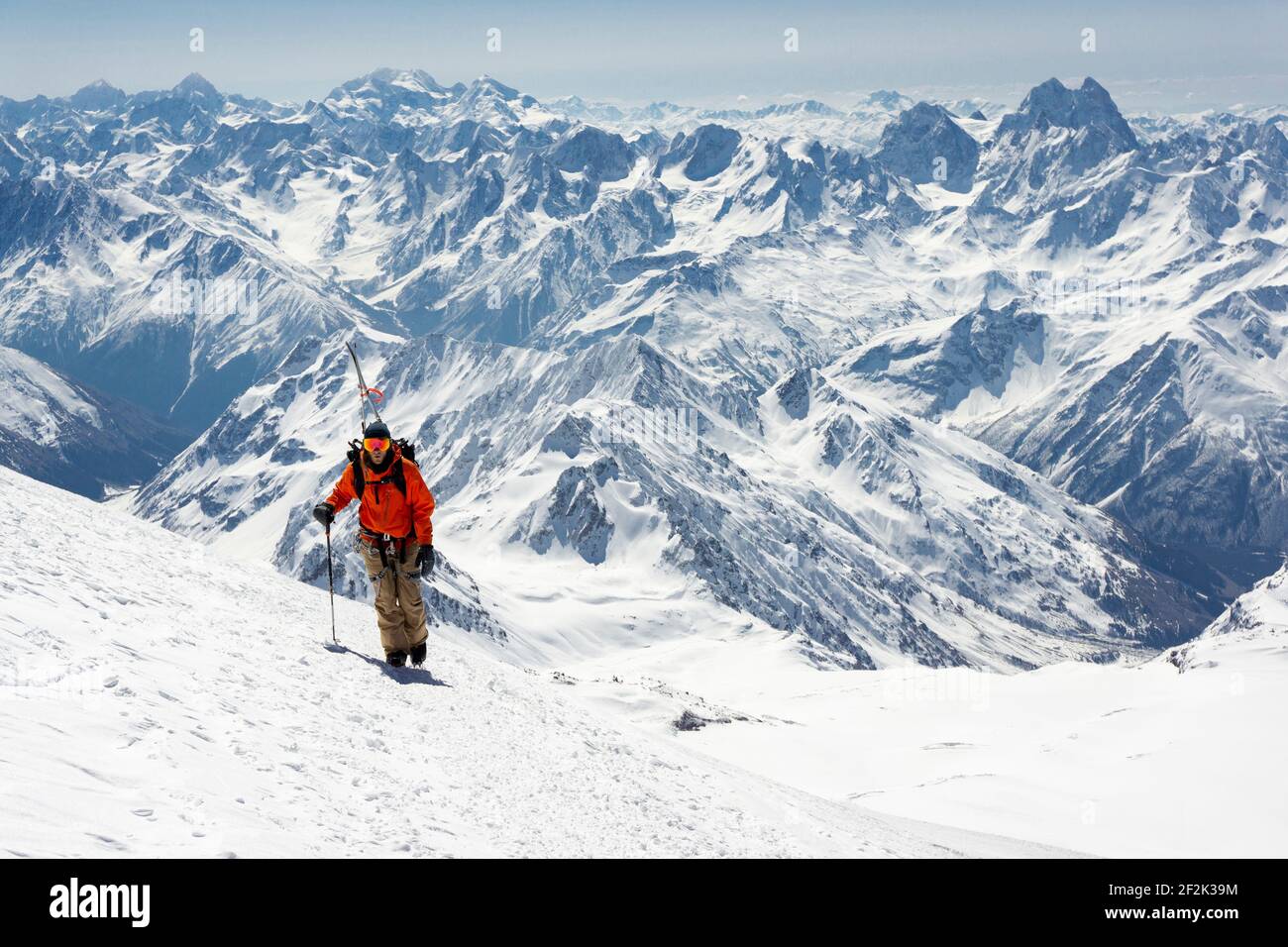 Uomo con polo di sci alpinismo montagna innevata durante le vacanze Foto Stock