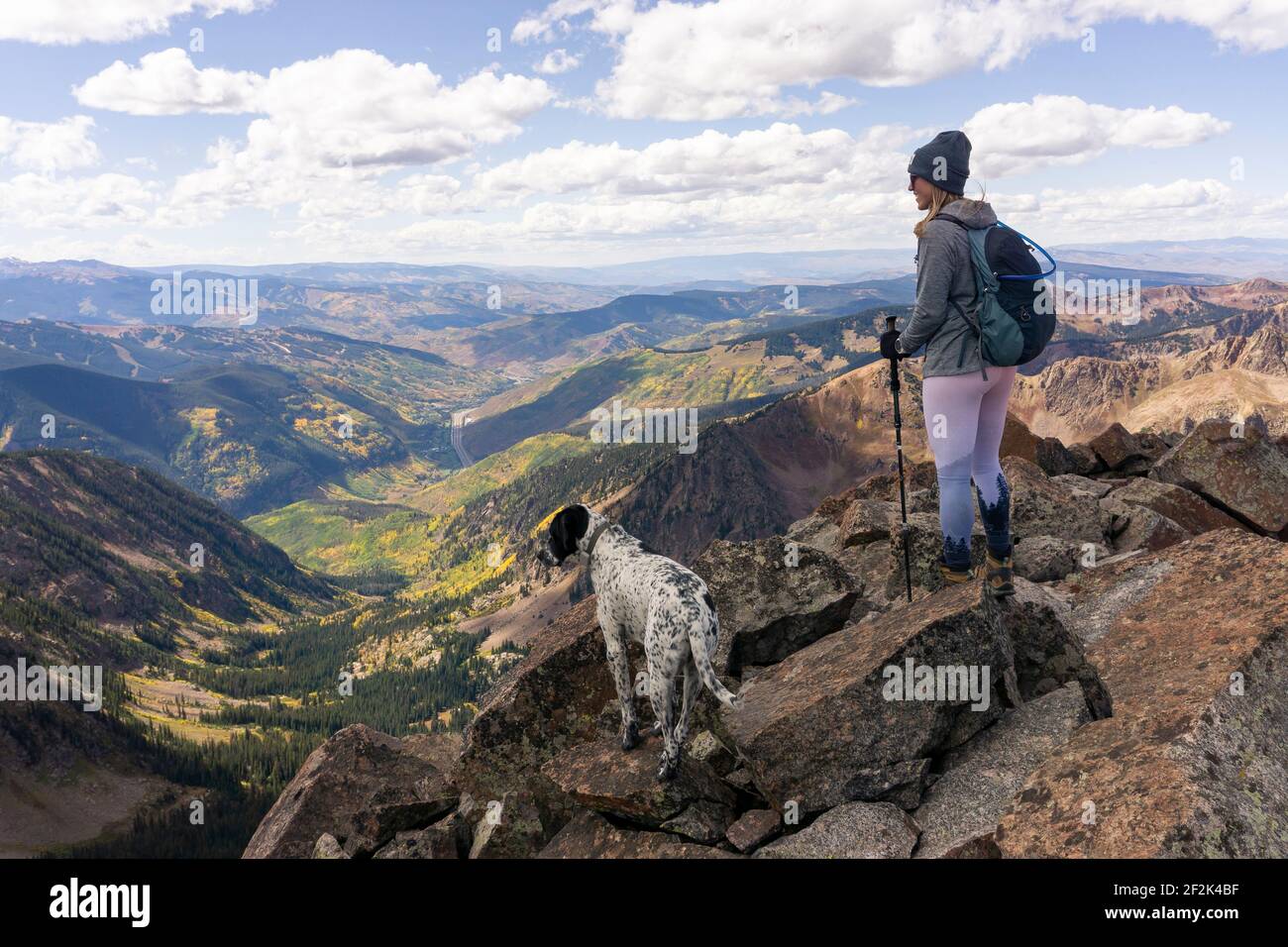 Donna escursioni con il cane in montagna contro il cielo durante la vacanza Foto Stock