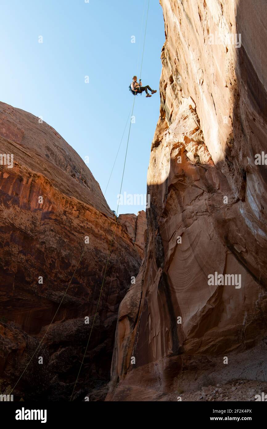 Vista ad angolo basso della giovane donna che si canyoneering sulla montagna Foto Stock