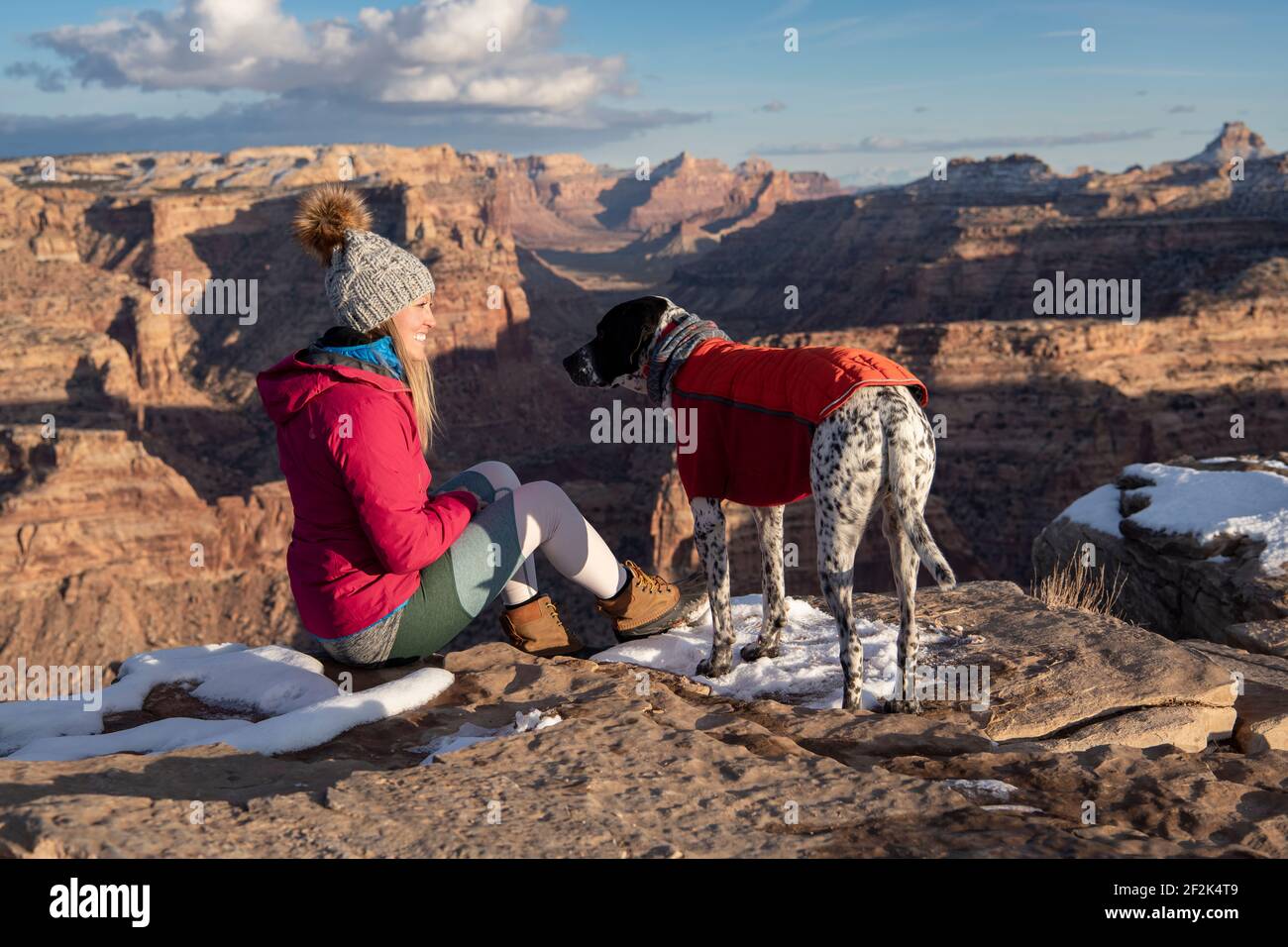 Donna sorridente trekking con il cane durante la vacanza Foto Stock