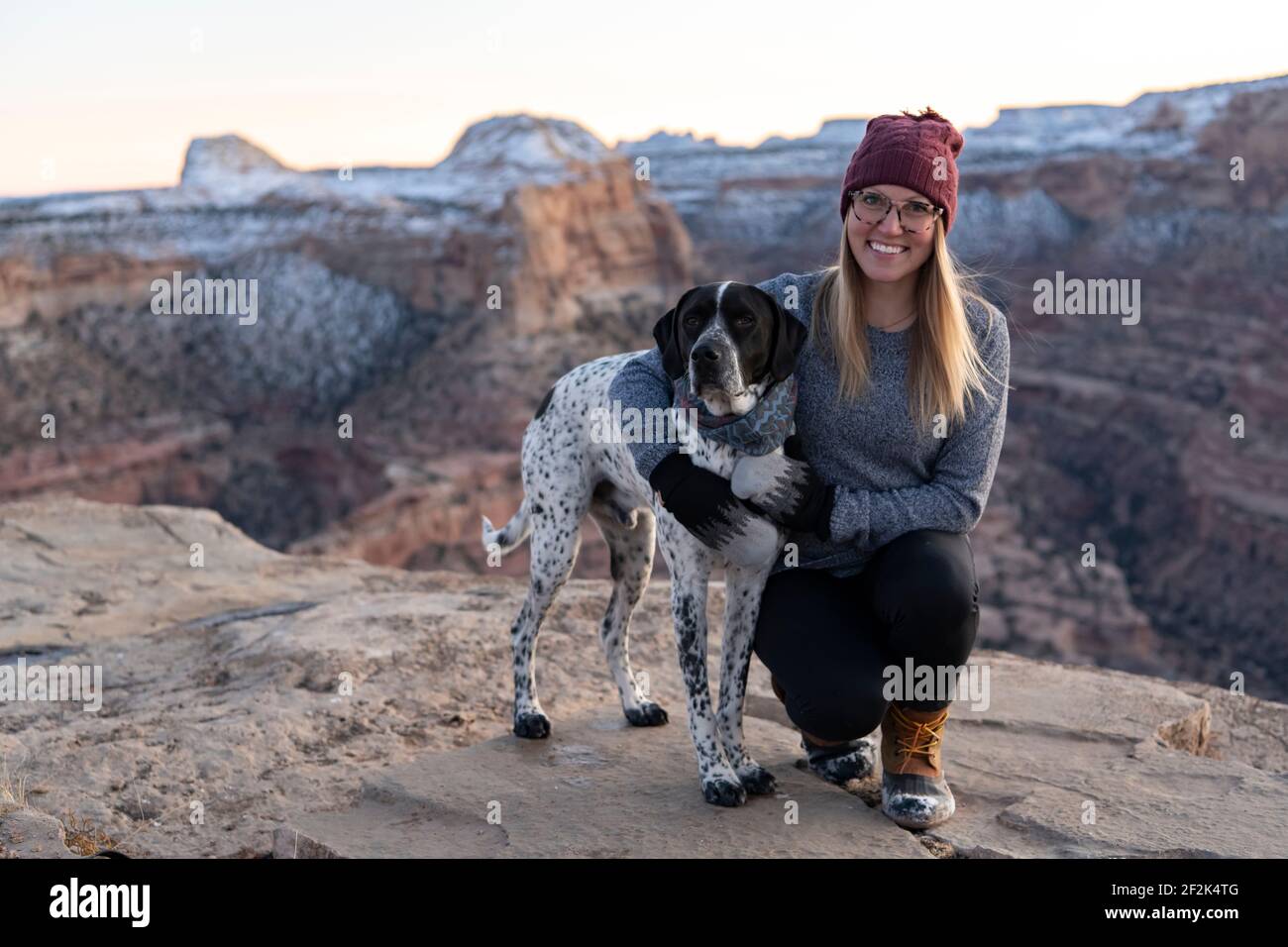 Donna sorridente trekking con il cane contro durante la vacanza Foto Stock