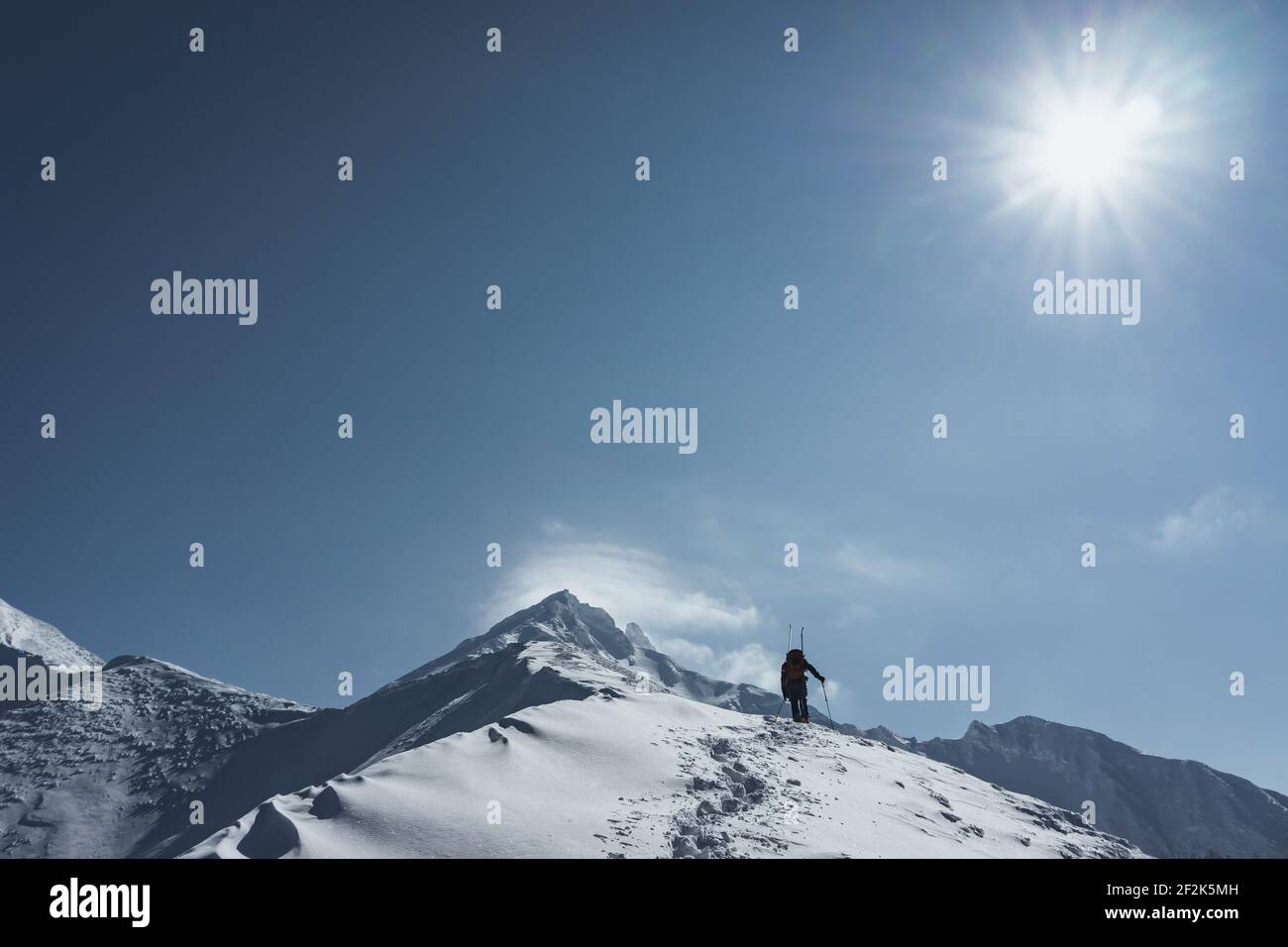 Vista a basso angolo dello splitboarding uomo contro il cielo durante il sole giorno Foto Stock