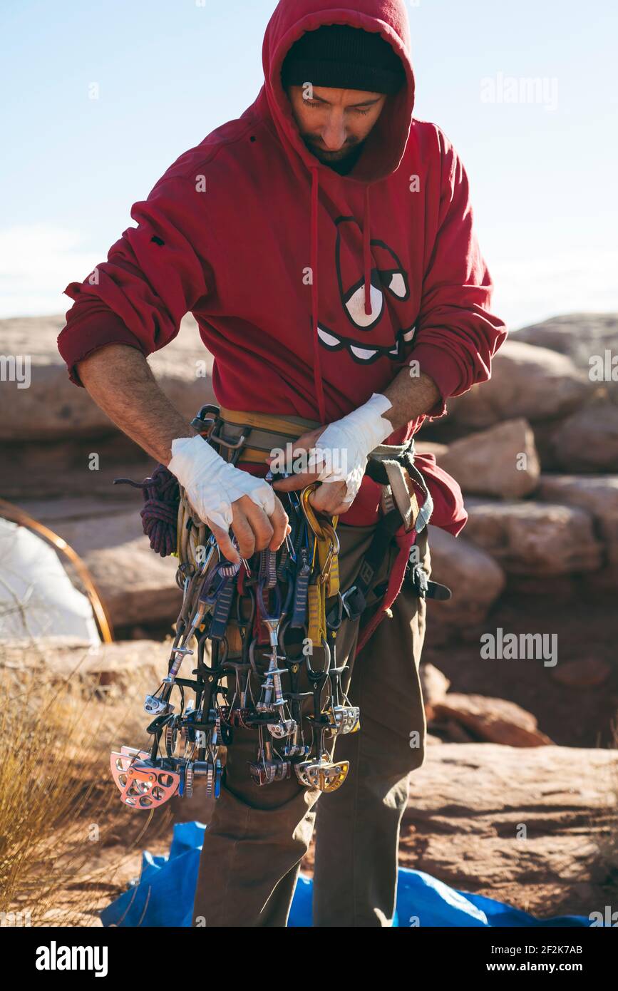 Uomo con attrezzatura da arrampicata sulla scogliera al Canyonlands National Park Foto Stock