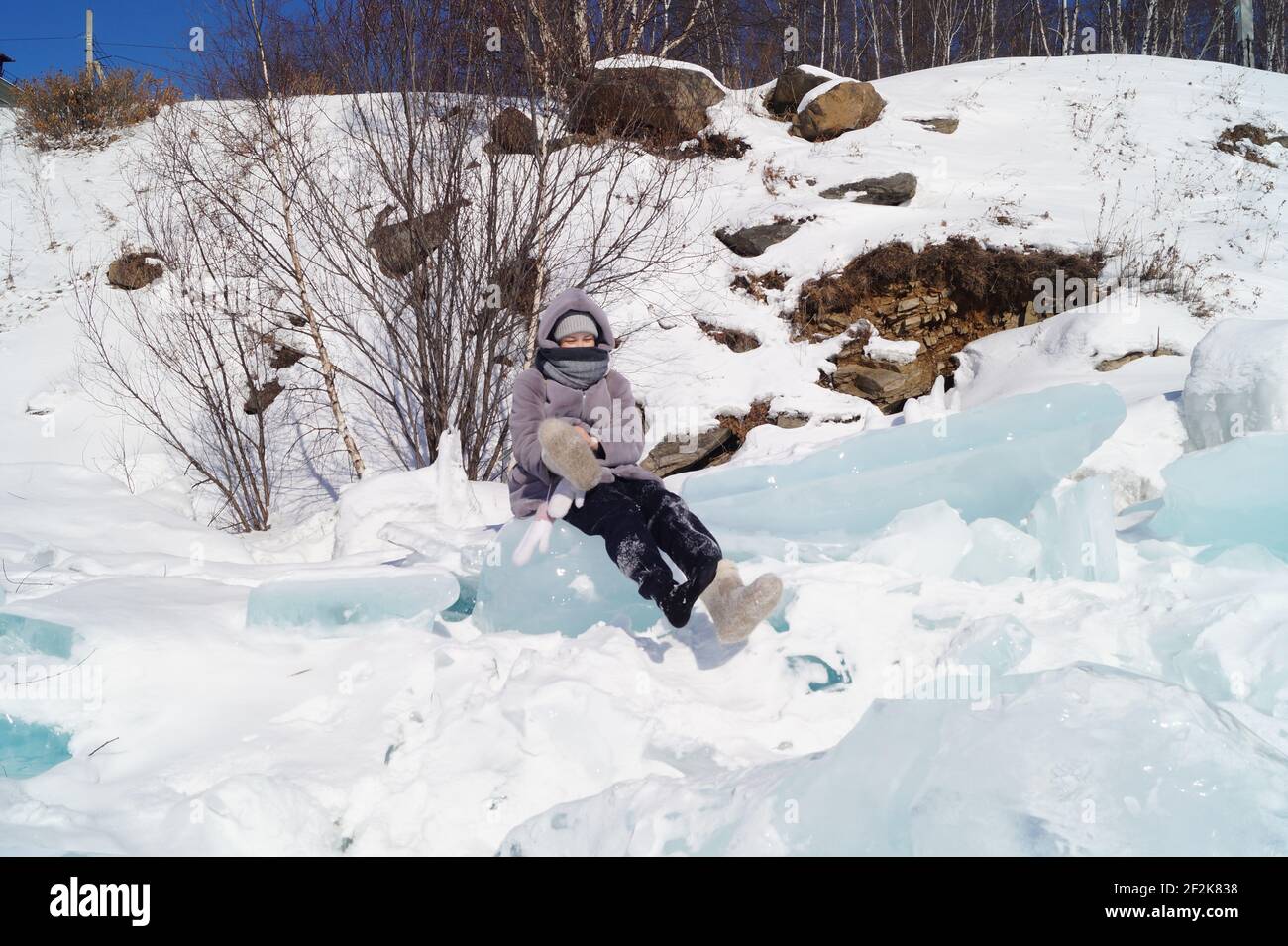Una ragazza di 10-15 anni si siede su un ghiaccio floe e mettere la sua mano i Foto Stock