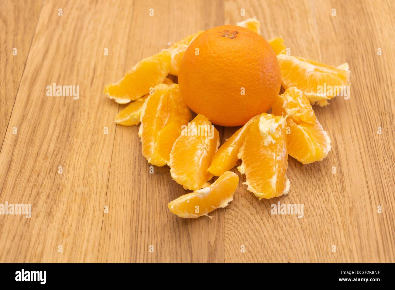 Una deliziosa frutta d'arancia e alcune fette intorno. Sfondo di legno. Concetto di vantaggi Orange. Foto Stock