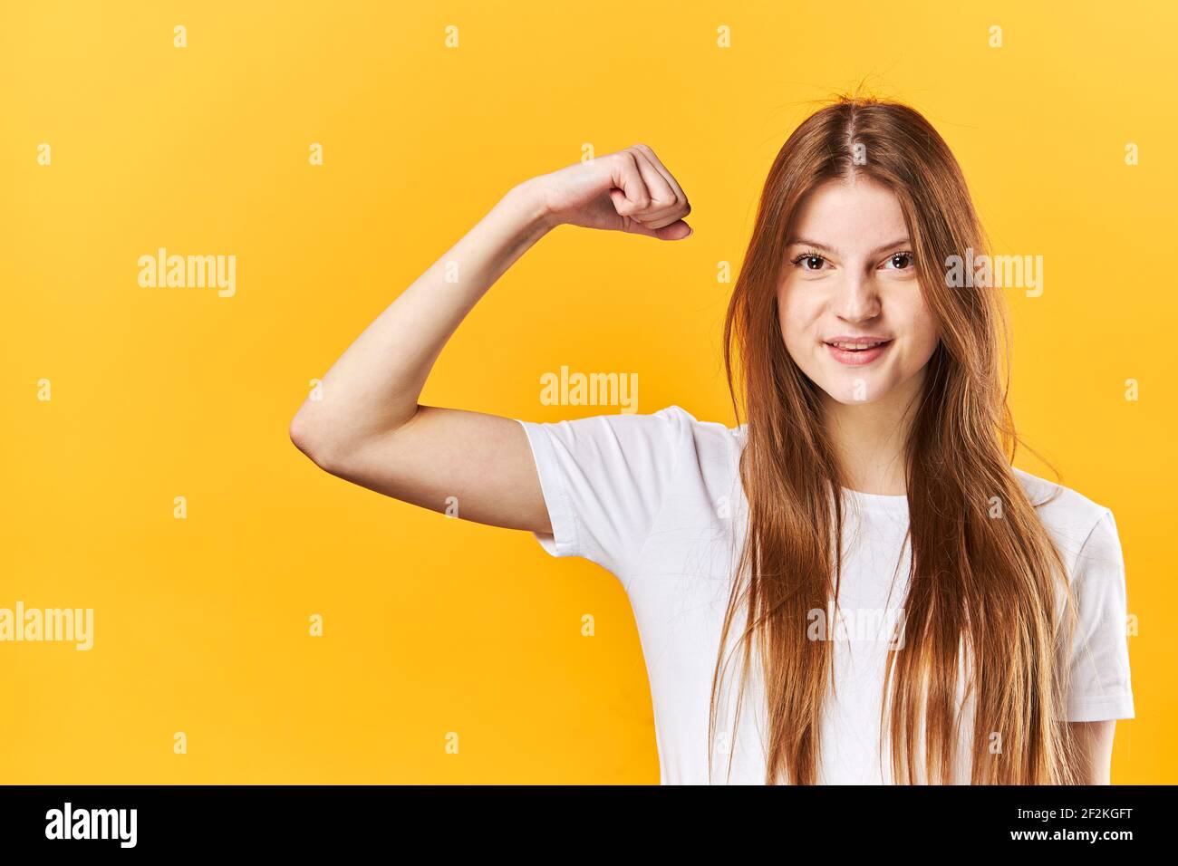 Giovane Donna mostra muscoli su braccio, mostra bicipiti. Il concetto di persone forti e potenti Foto Stock
