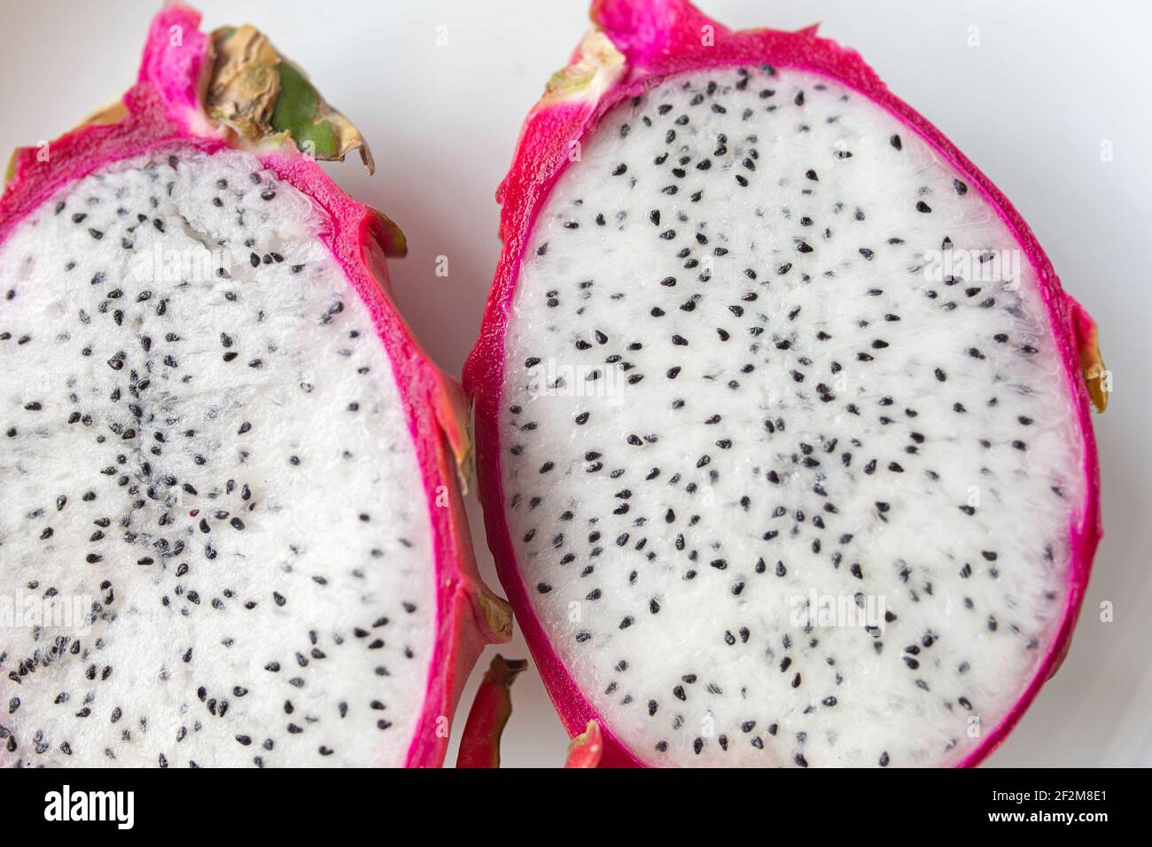 Pitahaya Polpa di frutta di drago. Primo piano di pitaya frutta tagliata a metà su un piatto bianco. Foto Stock