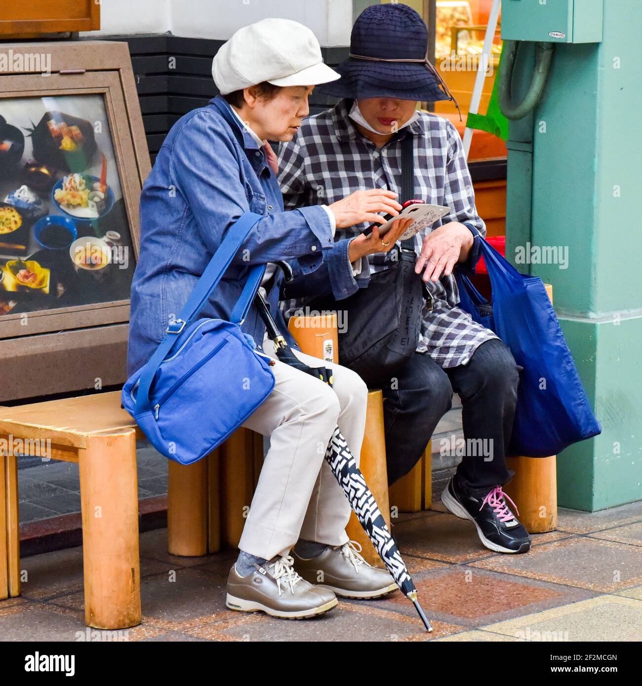 Le donne giapponesi più anziane che guardano i loro telefoni cellulari, Kyoto, Giappone Foto Stock