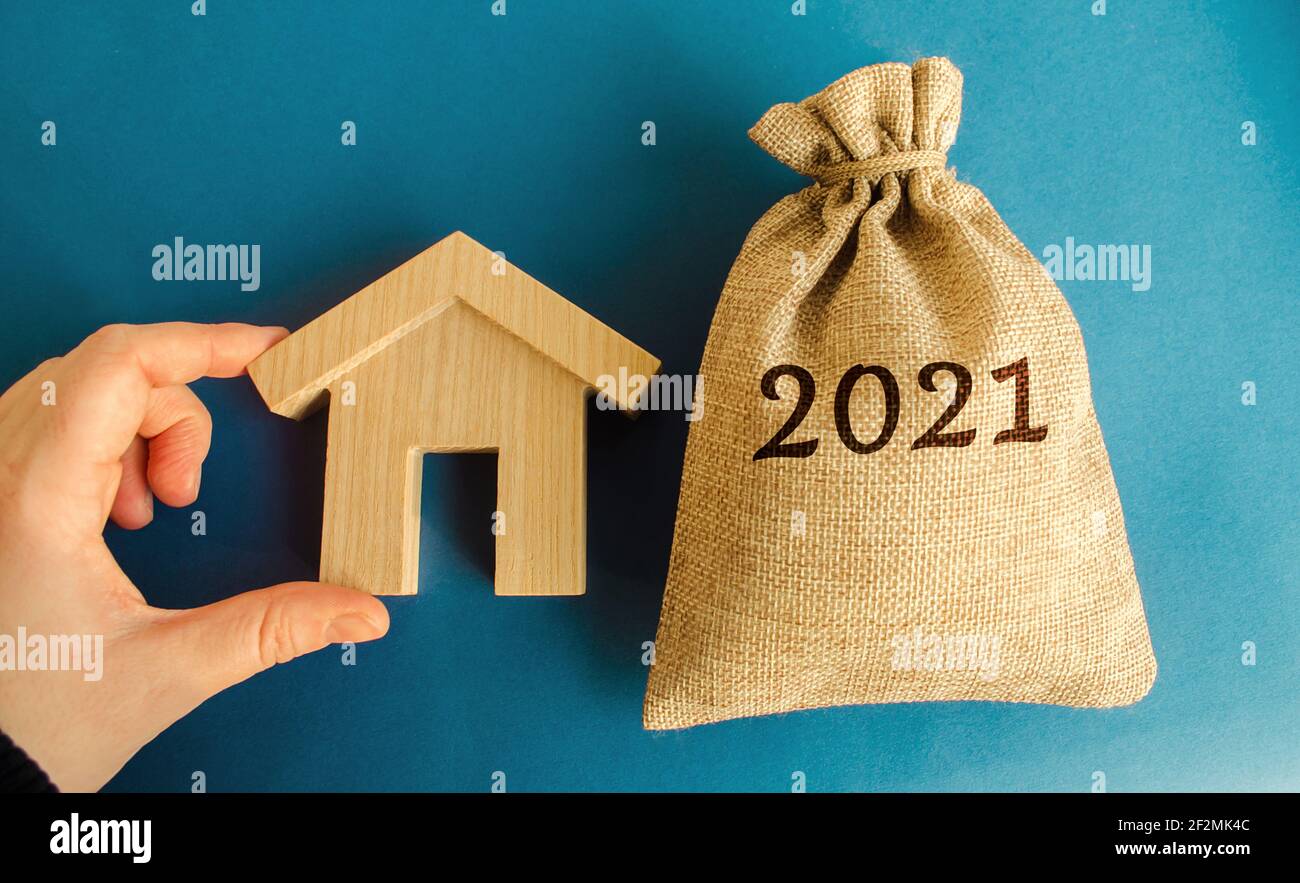 Borsa di denaro 2021 e una casa di legno. Concetto di bene immobile. Pianificazione del bilancio familiare. Investimenti, piani, risparmi. Tassi ipotecari e ipotecari. Previsioni. L Foto Stock