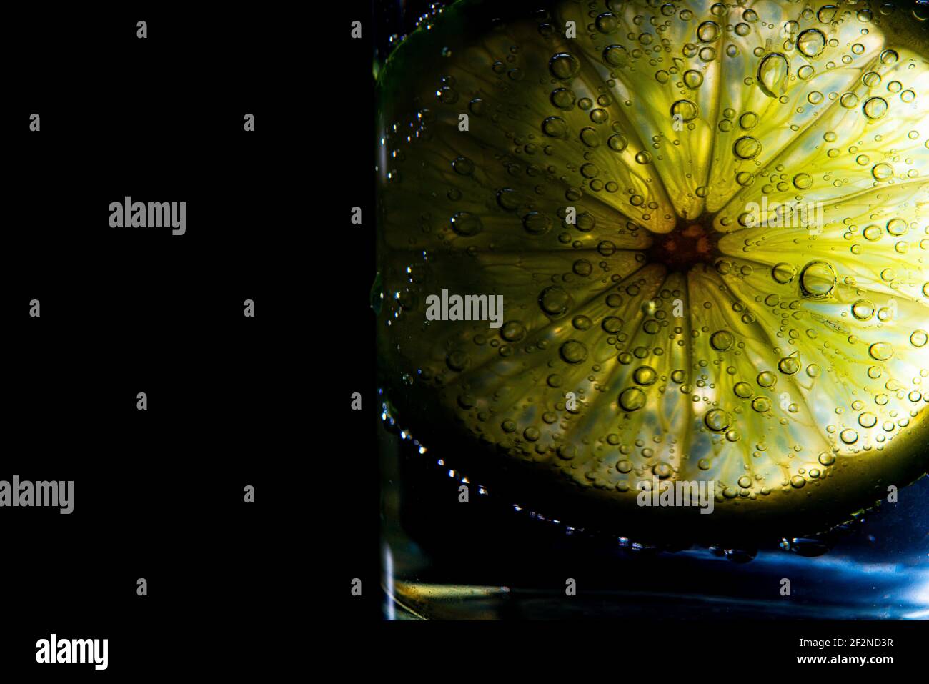 una fetta di frutta di lime in un'acqua frizzante Foto Stock