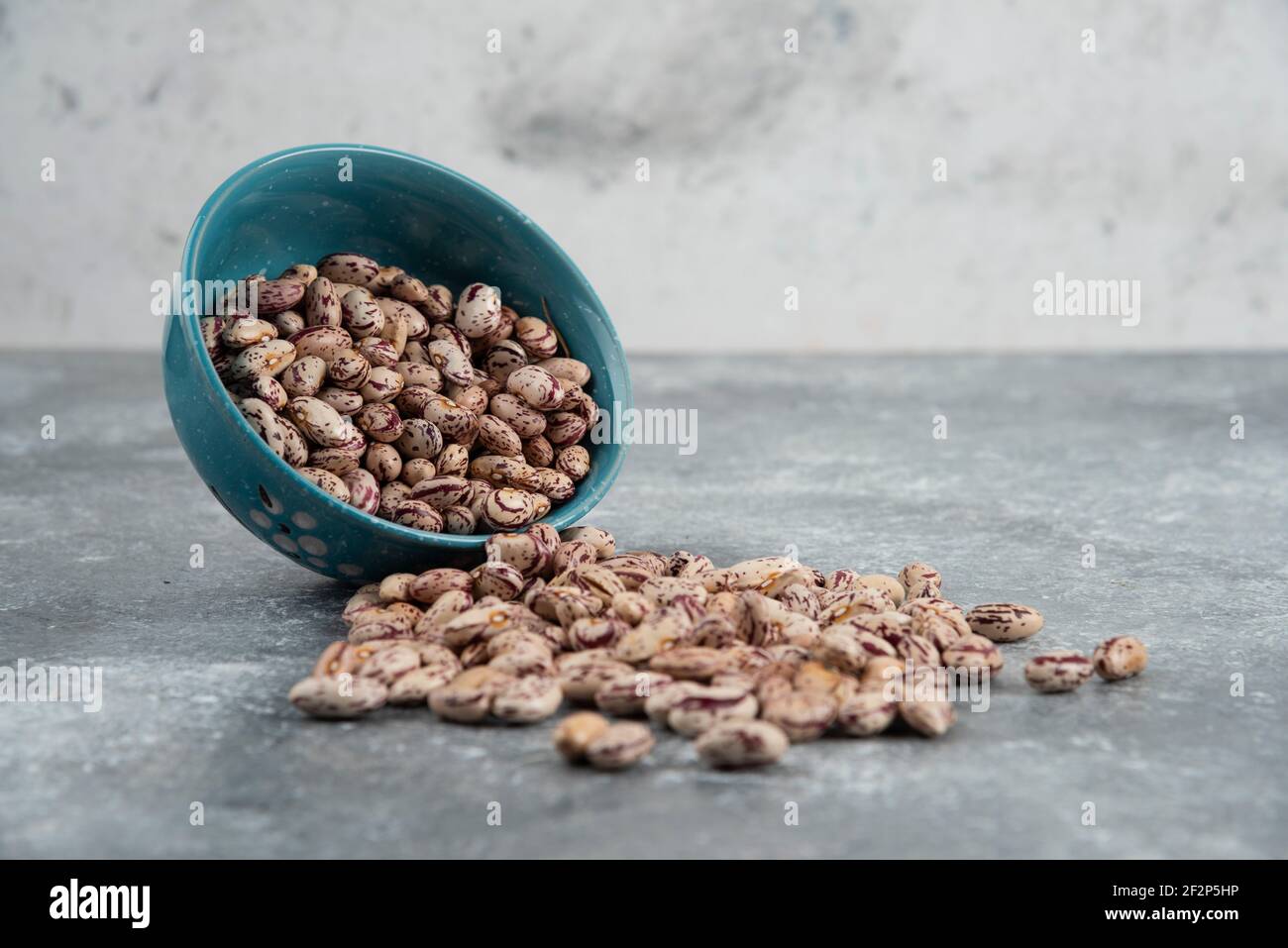 Grani grezzi di fagioli visualizzati in ciotole sulla superficie di marmo Foto Stock