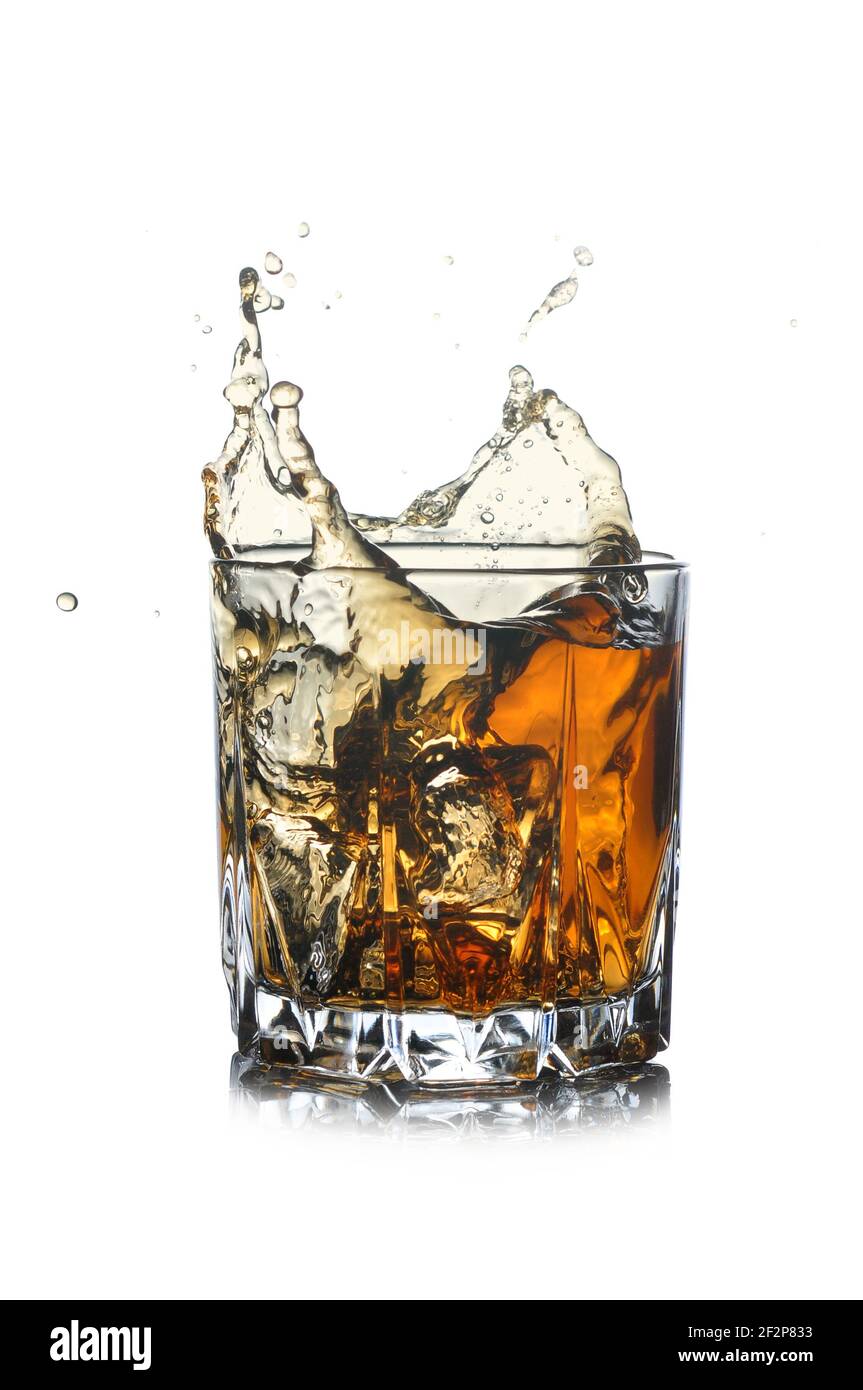 Vetro con spruzzi di whiskey isolato su sfondo bianco. Foto Stock