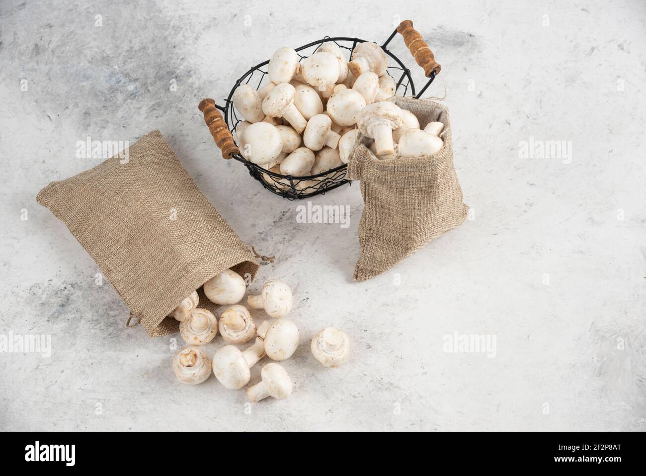 Funghi bianchi all'interno di cestini rustici e un vassoio metallico Foto Stock