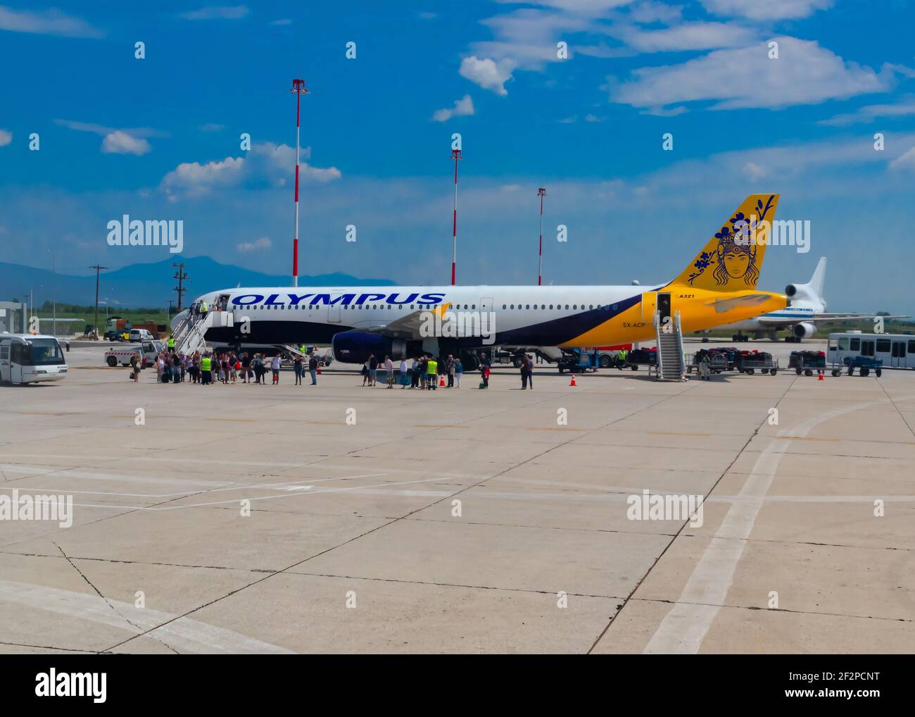 Aeroporto di Kavala, Grecia, 2019 giugno - Olympus Airlines, Airbus A321 con la livrea ibrida parcheggiata con scale e vacanzieri in attesa di salire a bordo. Immagine Foto Stock