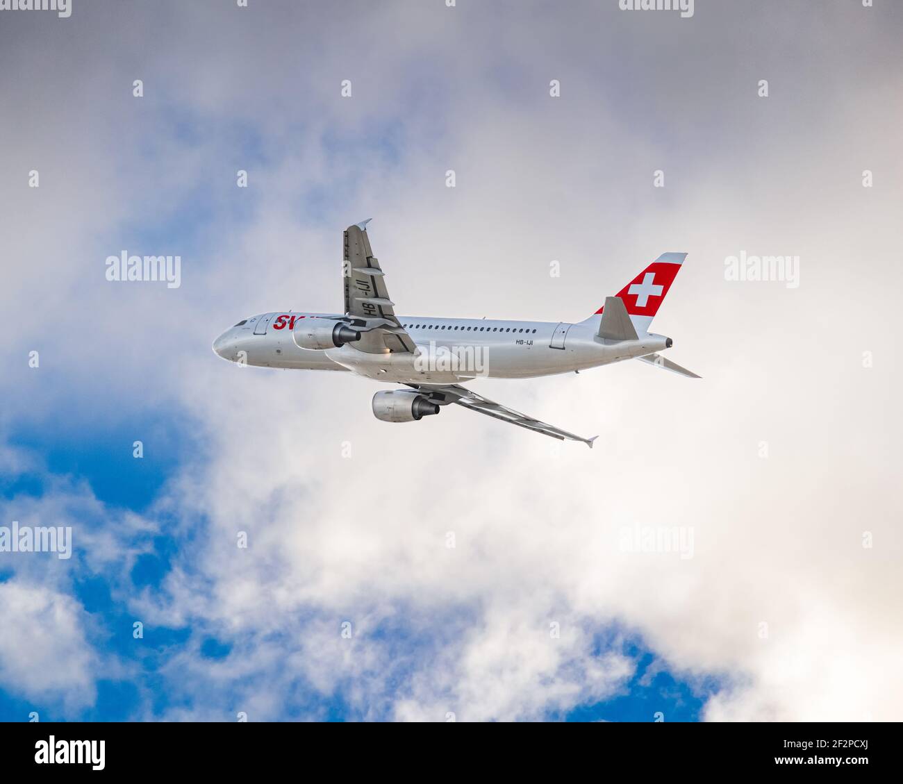 Londra, Regno Unito - Gennaio 2020: Swiss AIR, Airbus A320, banca a destra dopo il decollo attraverso le nuvole e dirigersi in un cielo blu più chiaro. Immagine Abdul Foto Stock