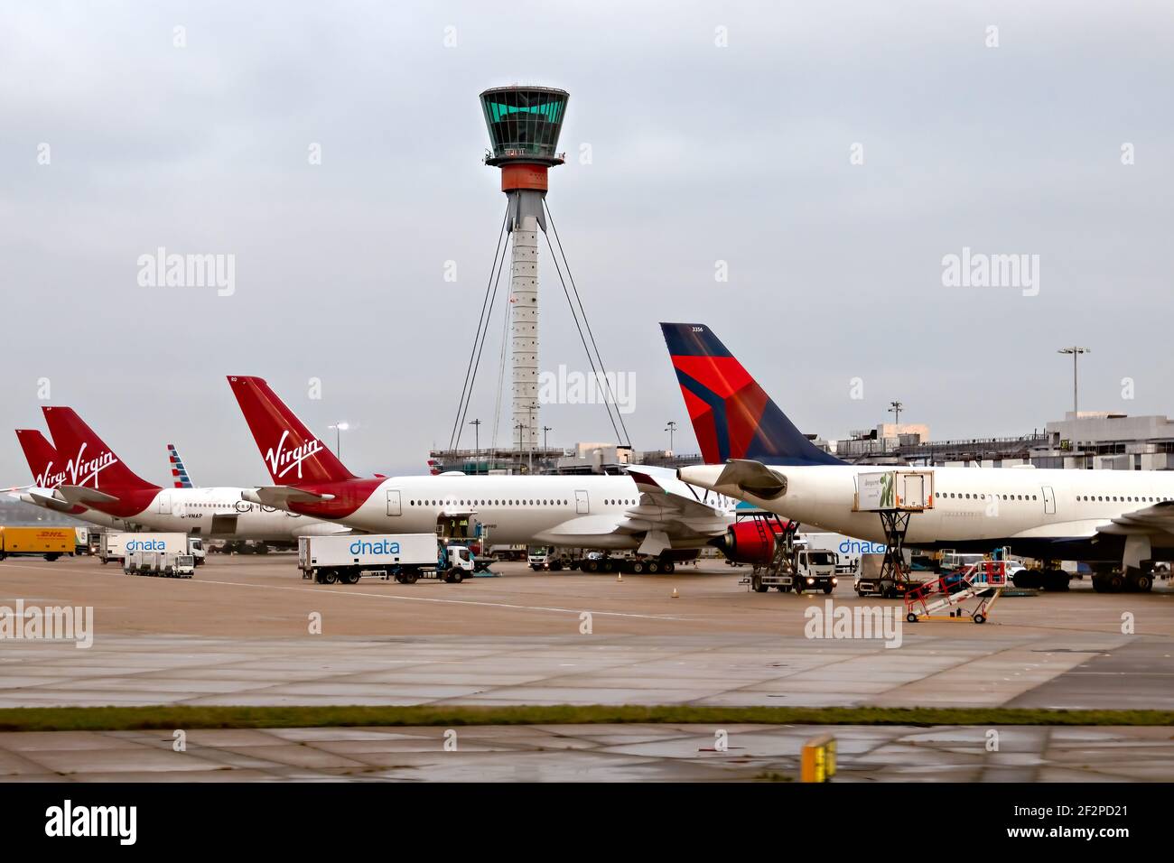 Aeroporto di Heathrow, Londra, 2019 novembre - aerei aerei, Virgin Atlantic e Delta parcheggiati e caricati al terminal con una torre fuori fuoco e. Foto Stock