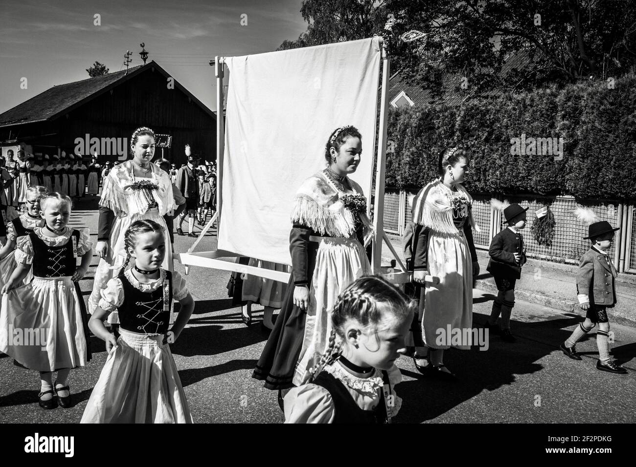 Germania, Baviera, Antdorf, settimana del festival dell'associazione dei costumi tradizionali. Sfilata in costume tradizionale attraverso il villaggio per benedire la nuova bandiera club al servizio sul campo. Foto Stock