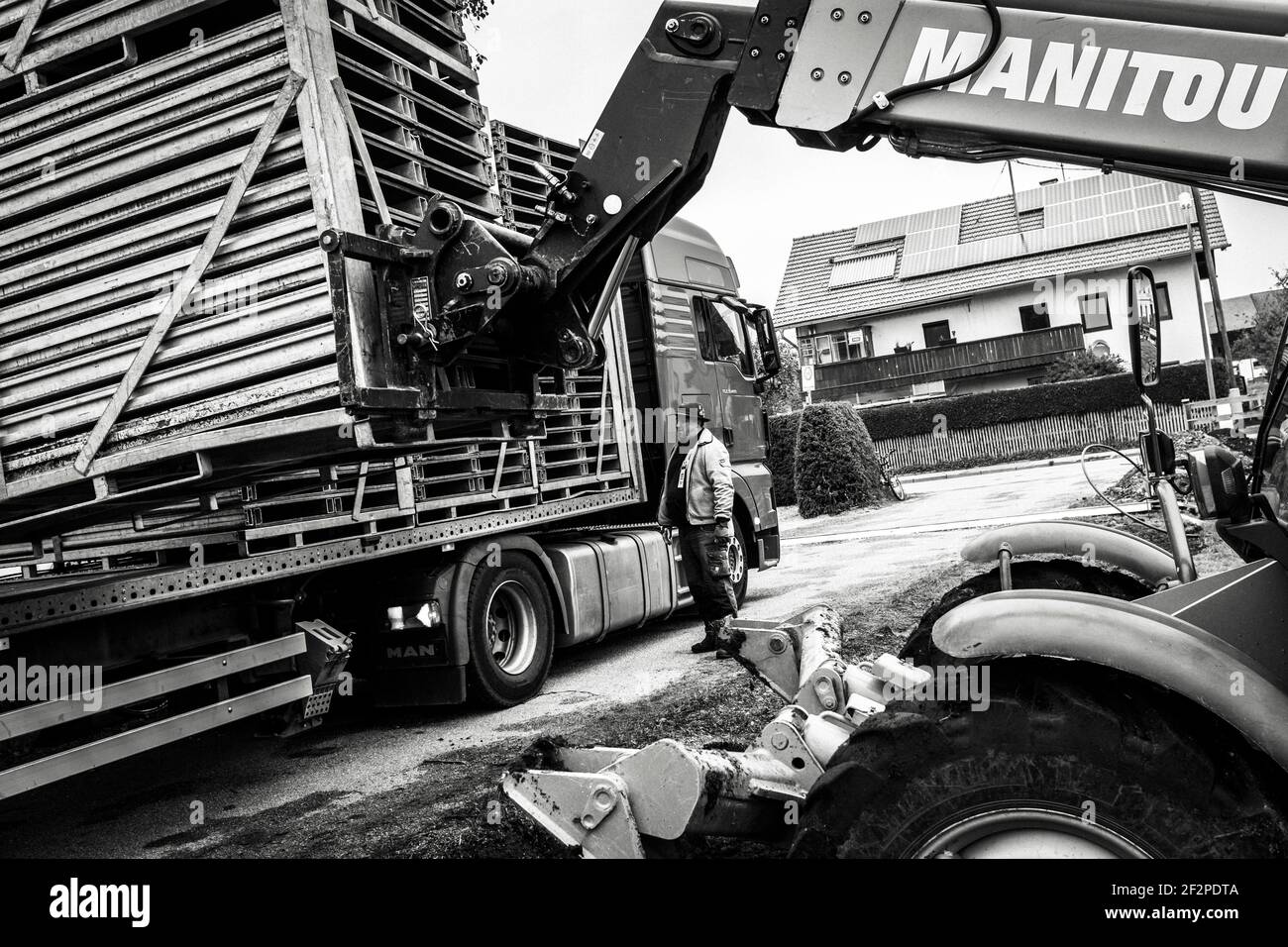 Germania, Baviera, Antdorf, settimana del festival dell'associazione dei costumi tradizionali. Il movimentatore telescopico scarica un carrello con pannelli a pavimento per il marchese. Foto Stock