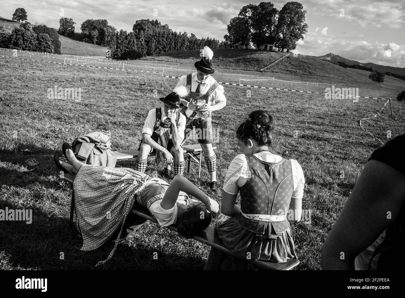 Germania, Baviera, Antdorf, settimana del festival dell'associazione dei costumi tradizionali. I ragazzi e le ragazze in costumi tradizionali riposano sul terreno fieristico. Foto Stock