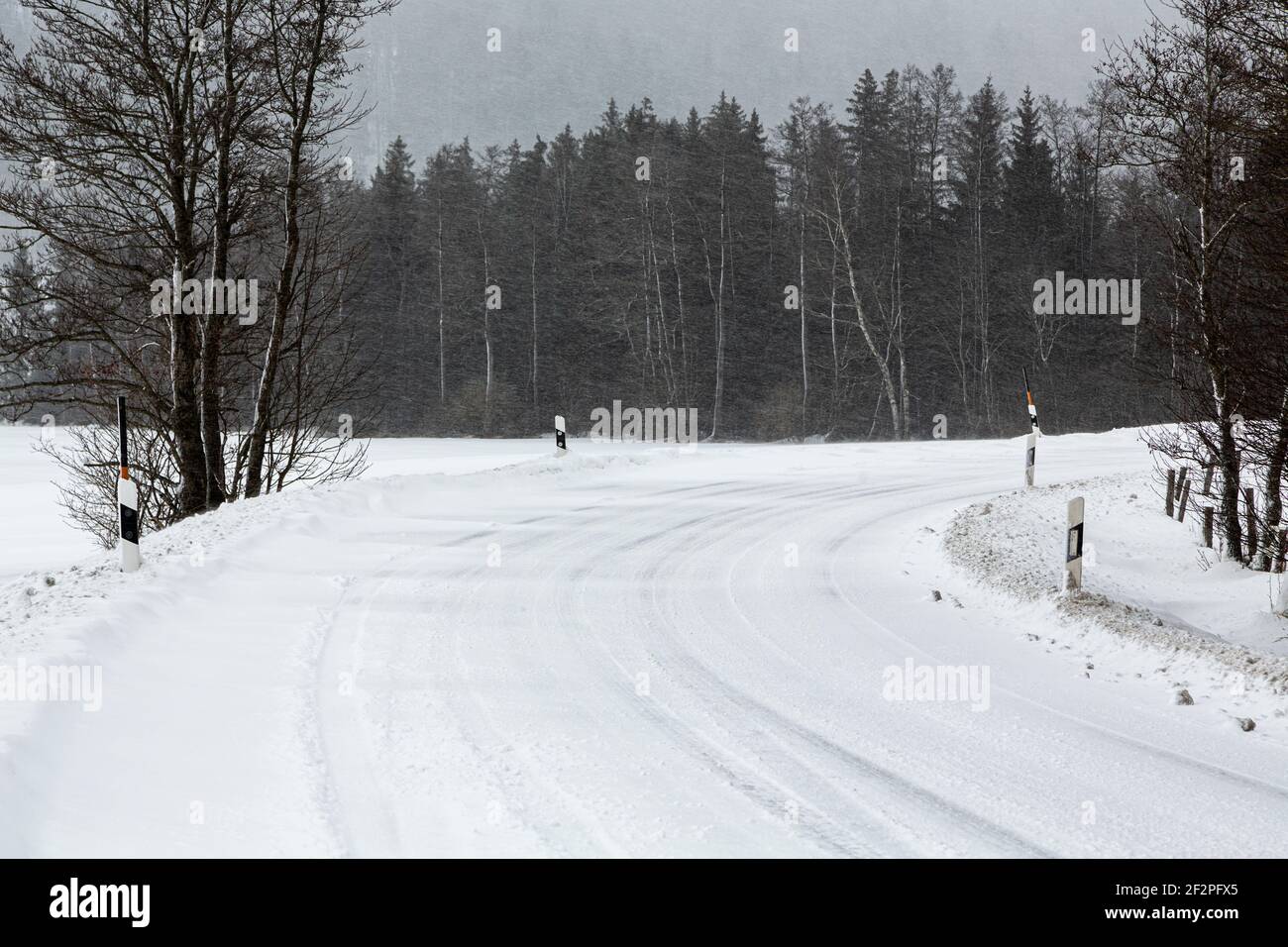 Germania, Baviera, strada di campagna innevata con cingoli pneumatici. Foto Stock