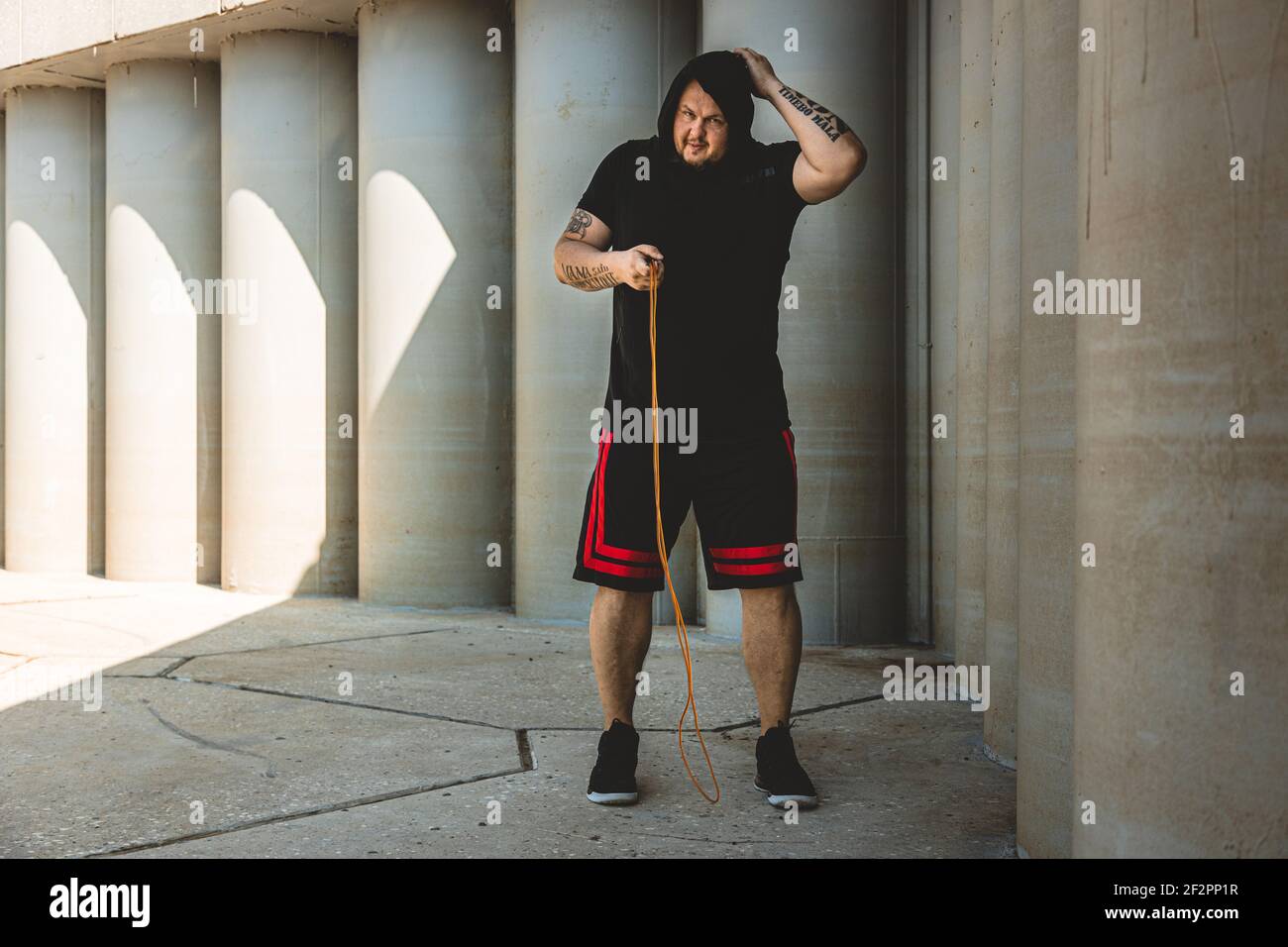 uomo caucasico combattente allenarsi duramente all'aperto.. Uomo che usa la corda, che fa il warm up. Concetto di sport e pugilato Foto Stock