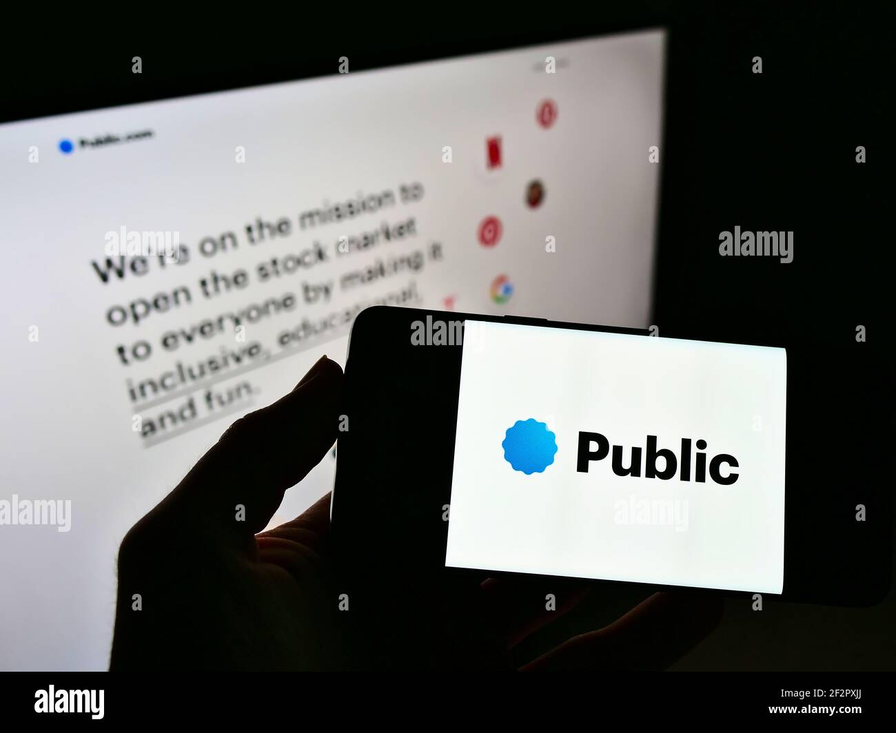 Persona che detiene smartphone con logo della piattaforma di investimento Public.com (Public Holdings Inc.) sullo schermo davanti al sito Web. Mettere a fuoco il display del telefono. Foto Stock
