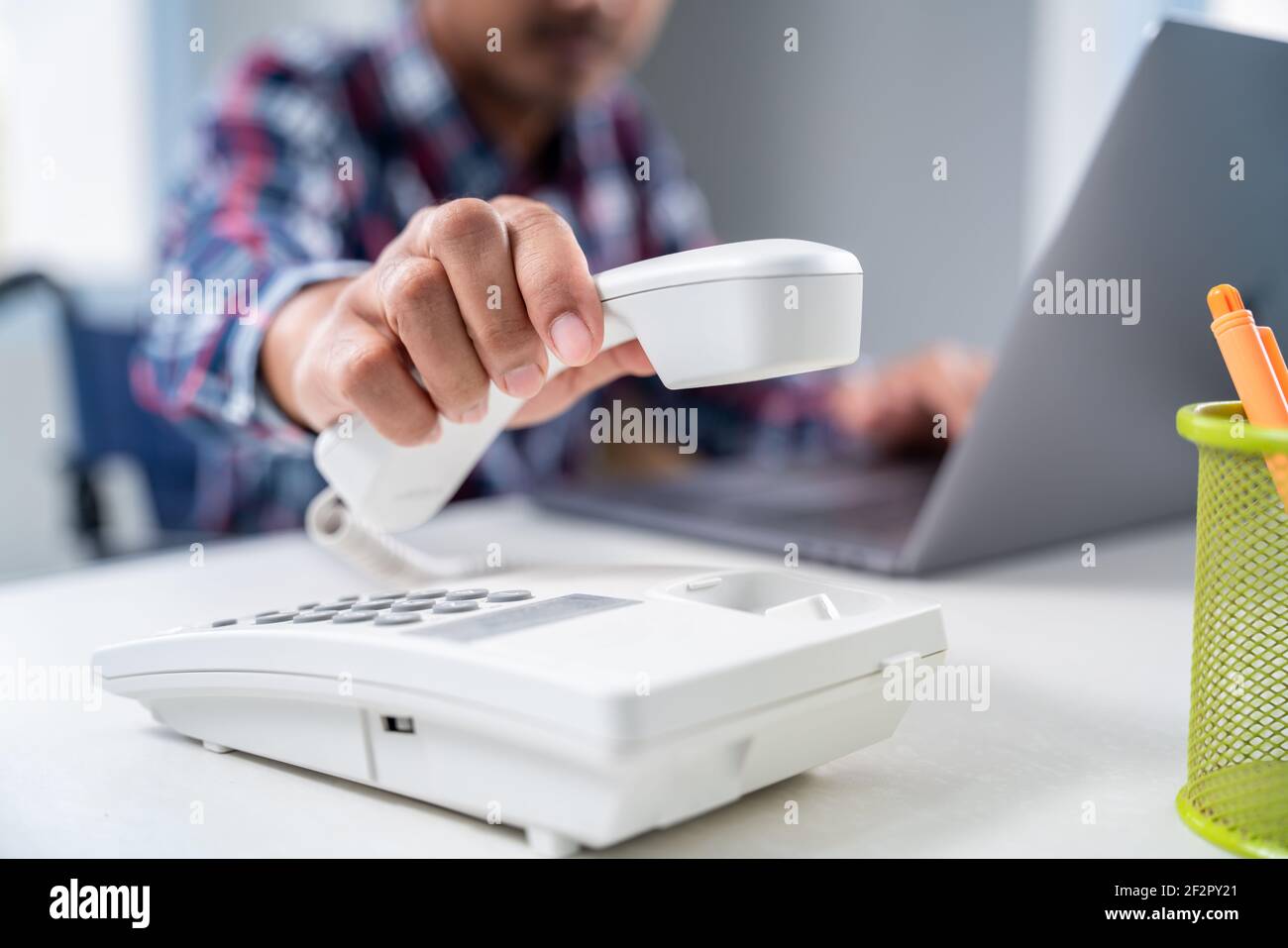 primo piano mano di uomo d'affari è mano prendere un telefono in ufficio. Foto Stock