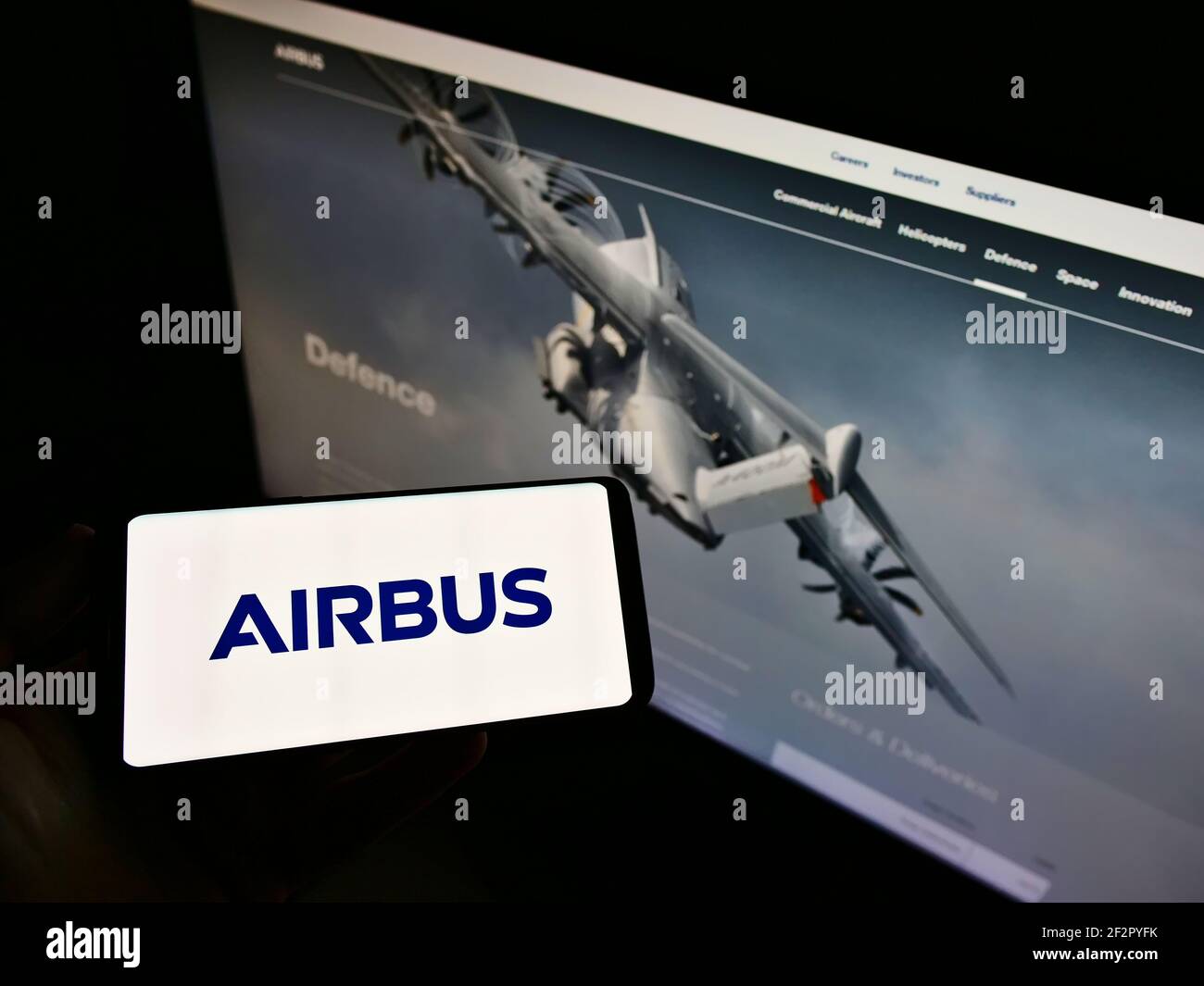 Persona che tiene il cellulare con il logo della società del produttore di aeromobili Airbus se sullo schermo di fronte alla pagina web aziendale. Mettere a fuoco il display del telefono. Foto Stock