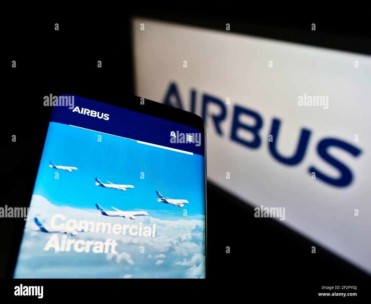 Persona in possesso di smartphone con il sito web aziendale del produttore di aerei Airbus se sullo schermo davanti al logo. Mettere a fuoco in alto a sinistra del display del telefono. Foto Stock
