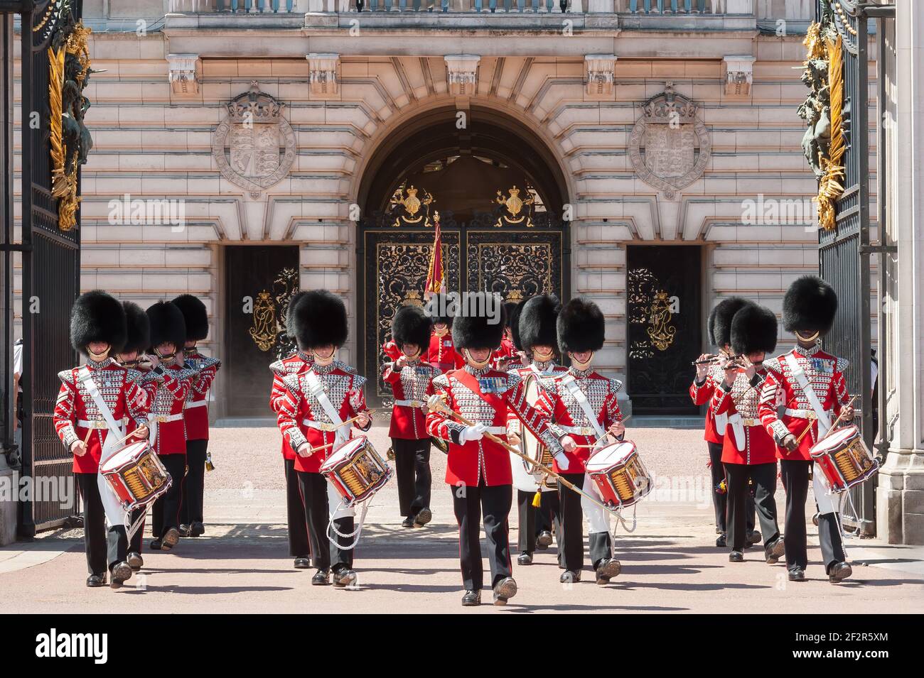 LONDRA, UK - 24 MAGGIO 2010: Vista della banda delle guardie di Grenadier che marciano attraverso le porte di Buckingham Palace durante il cambio della guardia Foto Stock