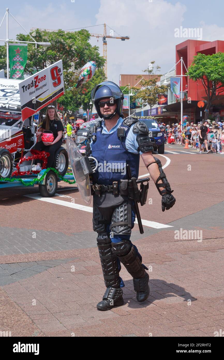 Un poliziotto neozelandese in equipaggiamento da sommossa (casco, corazza e scudo) che partecipa a una sfilata. Tauranga, Nuova Zelanda Foto Stock