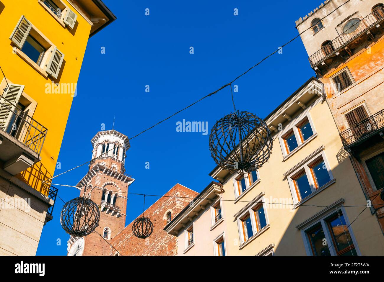 Torre Lamberti di Verona (Torre dei Lamberti) e case colorate circostanti nel centro della città. Bel cielo blu, tempo invernale. Italia Foto Stock