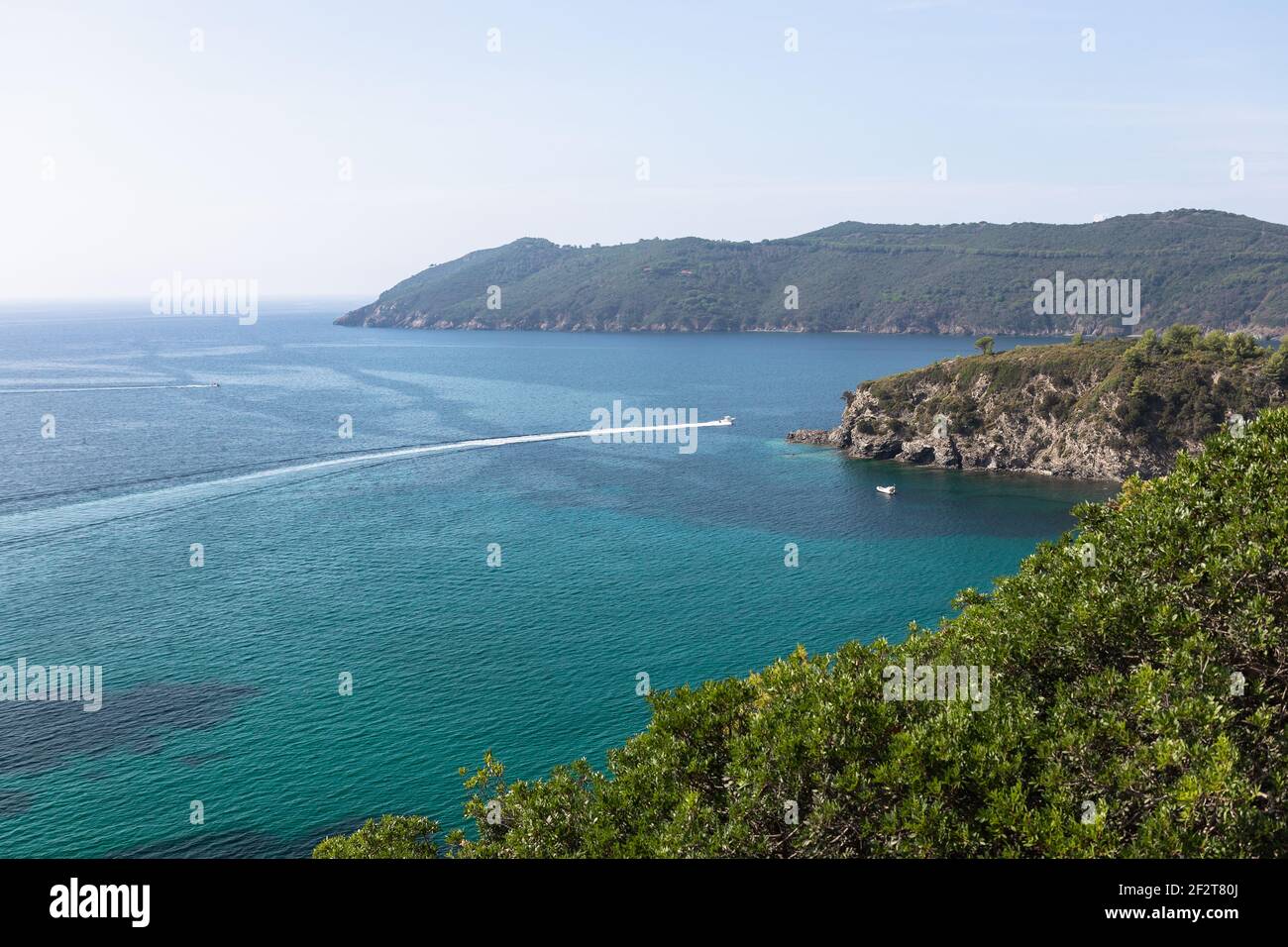 Bella vista mare o il mare smeraldo dell'isola d'Elba in Toscana con un motoscafo che attraversa l'orizzonte. Isola d'Elba, Toscana, Italia Foto Stock