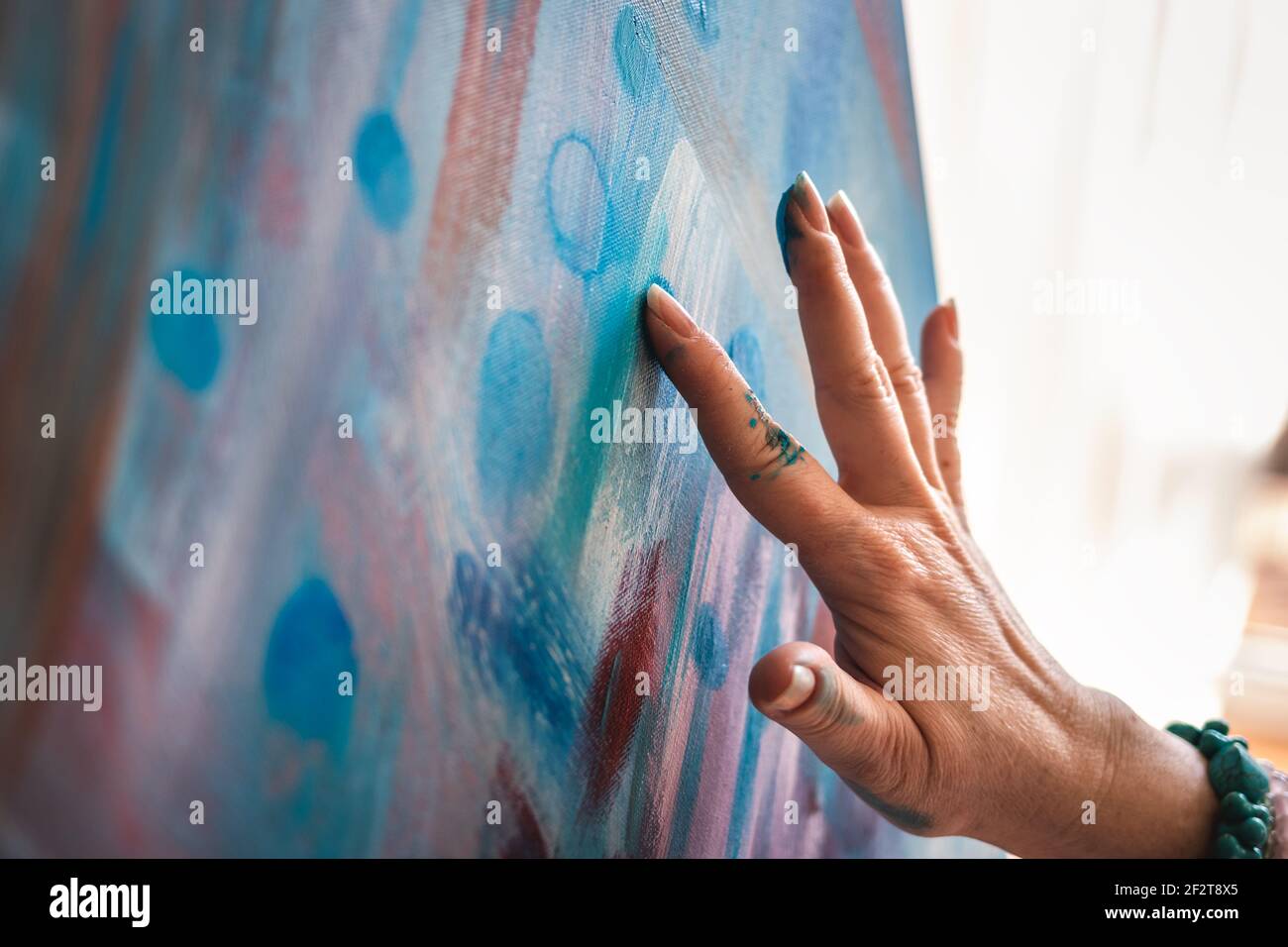 Dipingere su tela usando solo le mani e le dita. Dipinti astratti d'arte.  Artista donna che lavora nel suo studio Foto stock - Alamy