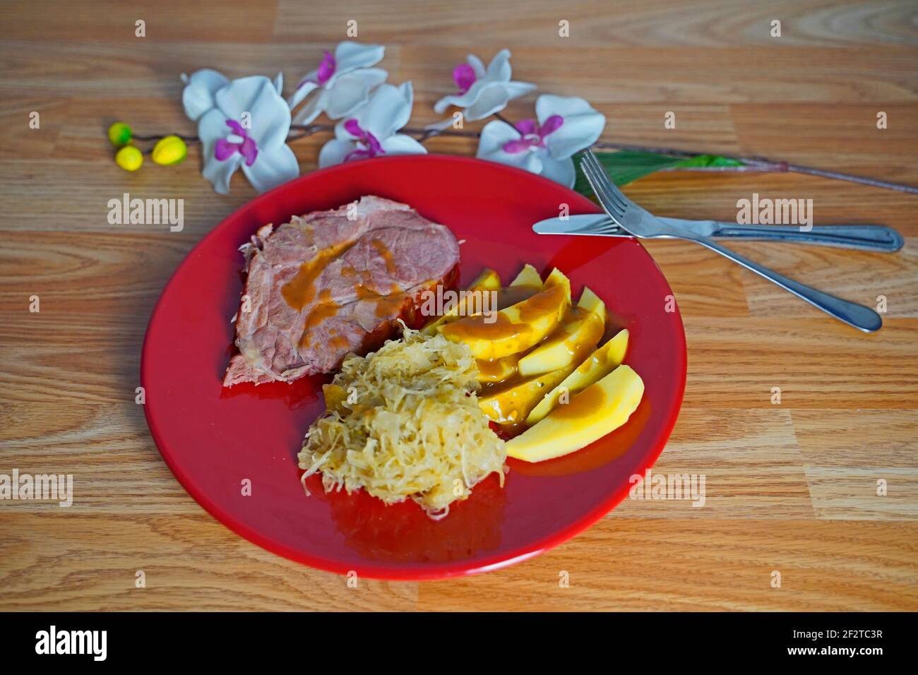 carne salata con crauti e spicchi di patate arrangiati in rosso piastra Foto Stock