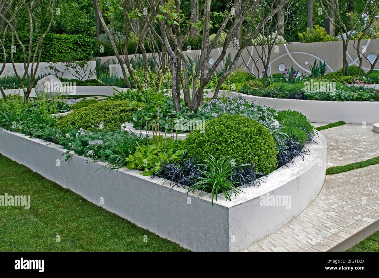 Moderno giardino d'acqua con sculture e letti rialzati Foto Stock