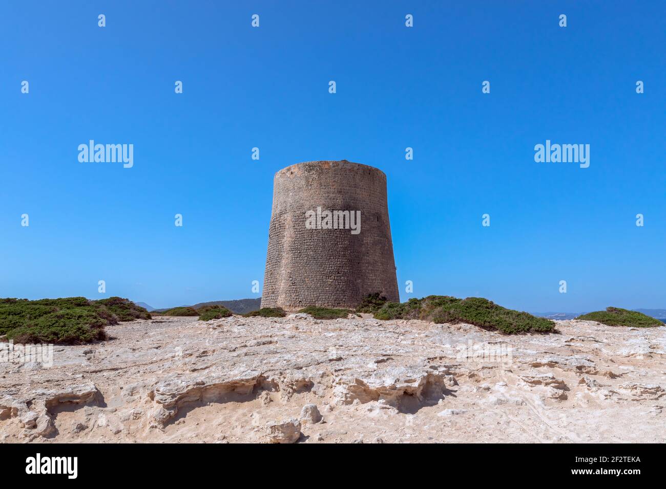 Vista della vecchia torre di osservazione Torre De Ses Portes sulla costa dell'isola di Ibiza. Foto Stock